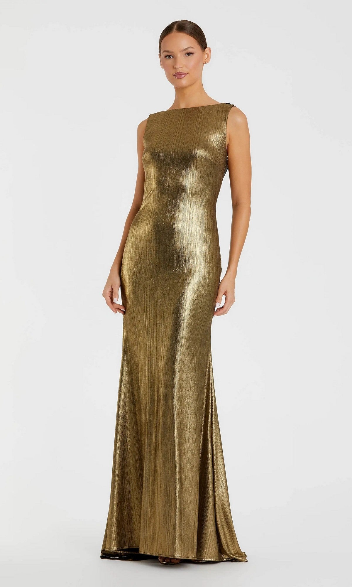 A woman wears the Mac Duggal 49087 V-Back Long Metallic Prom Dress, a sleeveless, floor-length gown with a fitted silhouette and cowl back, in gold, posed against a plain background.