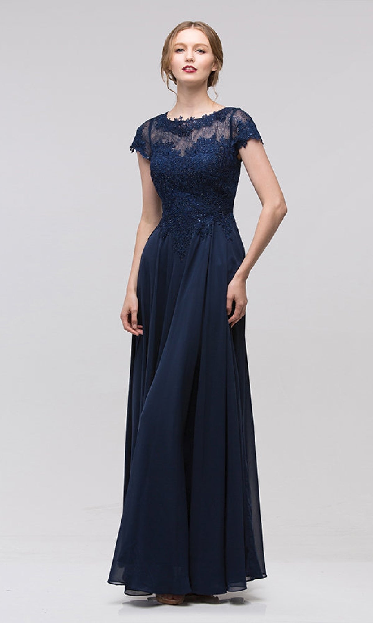 A woman wears the Eureka 4909, a floor-length navy blue chiffon A-line formal dress with short sleeves and an embroidered lace bodice, standing against a plain background.