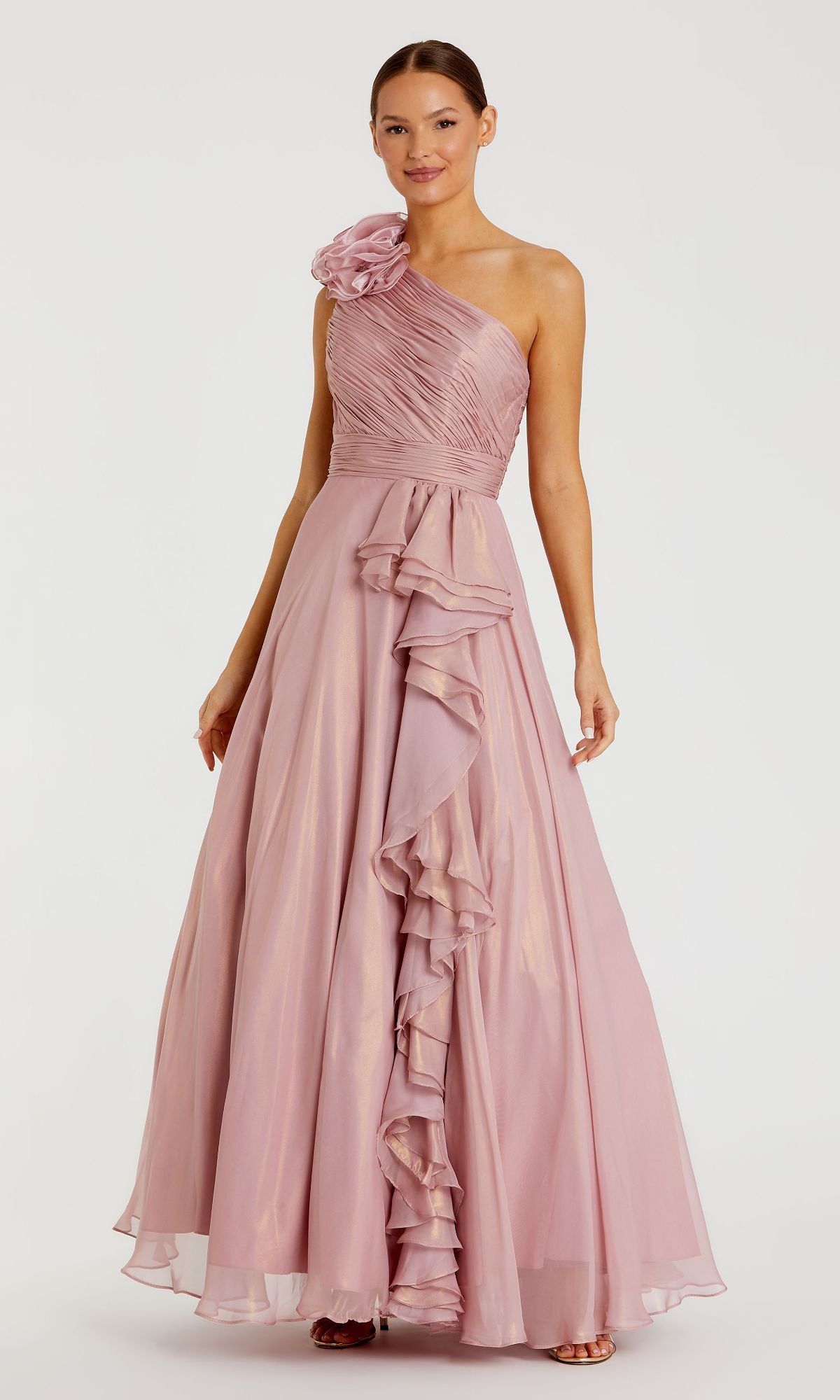 Woman wearing the Mac Duggal 49252 long rose gold formal dress, featuring a floor-length silhouette, one-shoulder design with floral shoulder detail, and elegant ruffle accents down the front.