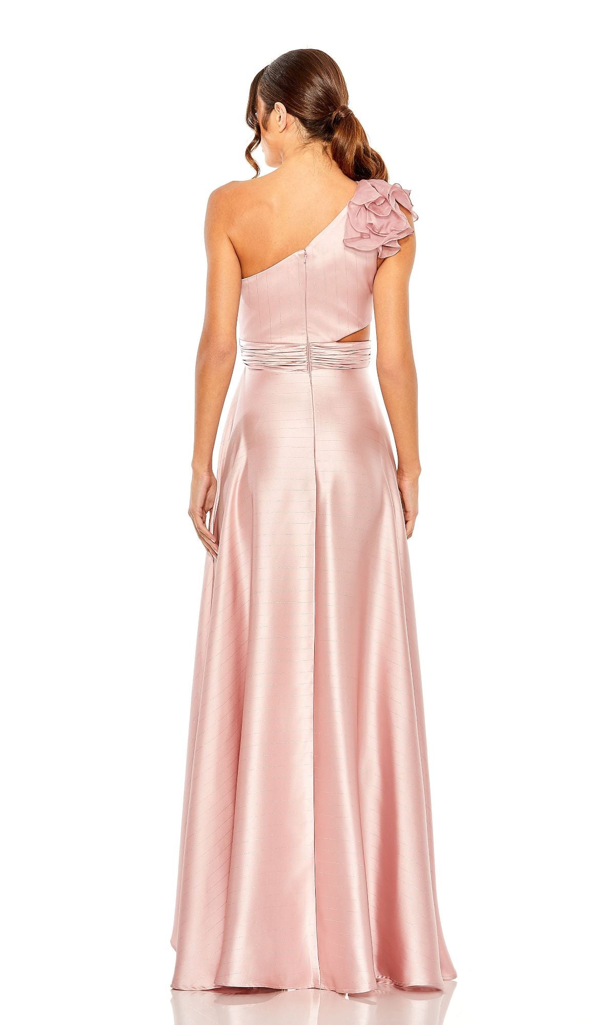 Woman in the Mac Duggal 49523 one-shoulder wedding guest dress, a long light pink gown with a floral detail and left shoulder cut-out, perfect as a high-low style, shown from the back.