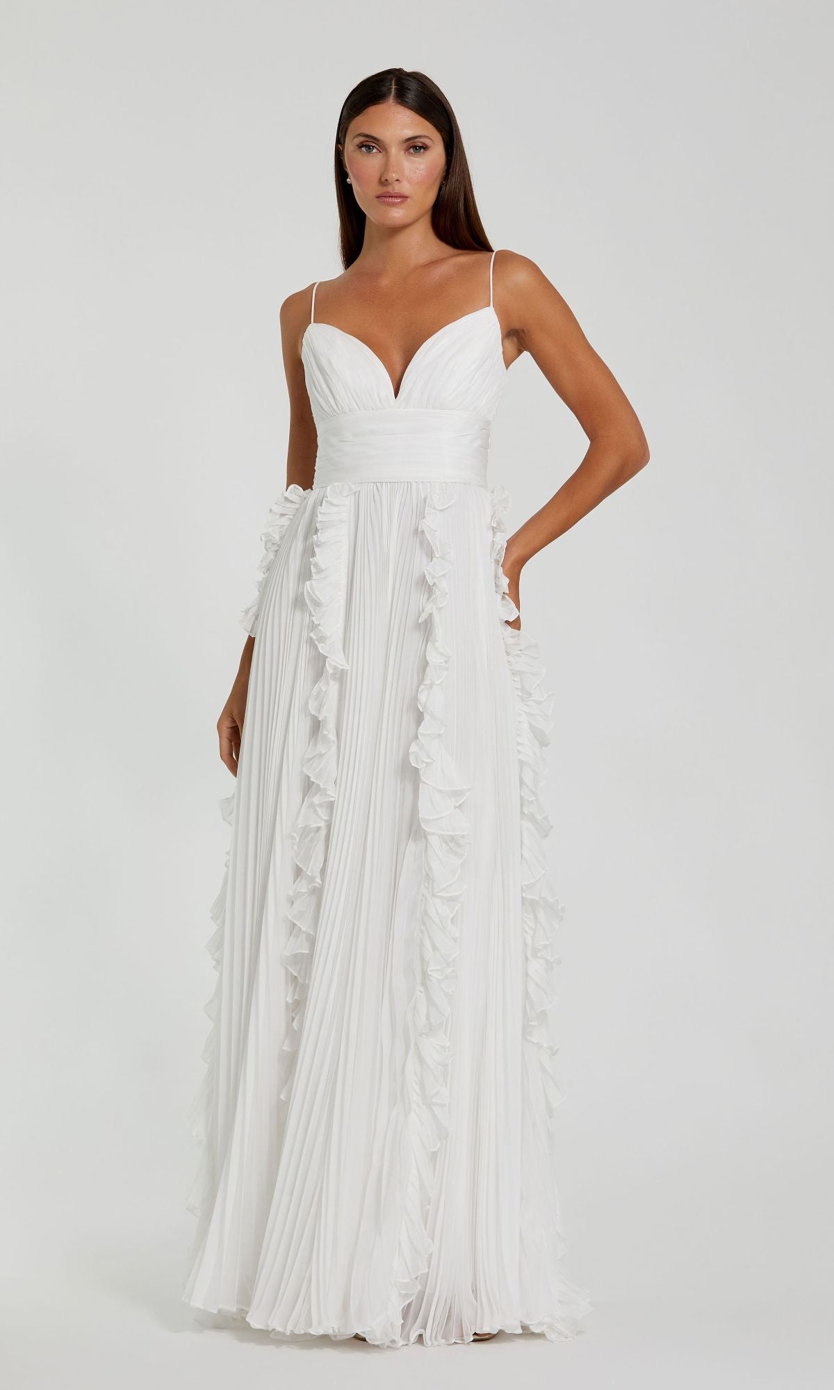 A woman in the Ruffled Long White Formal Dress 49533—featuring thin straps, a deep V neckline, and ruffle details—stands elegantly against a plain background.