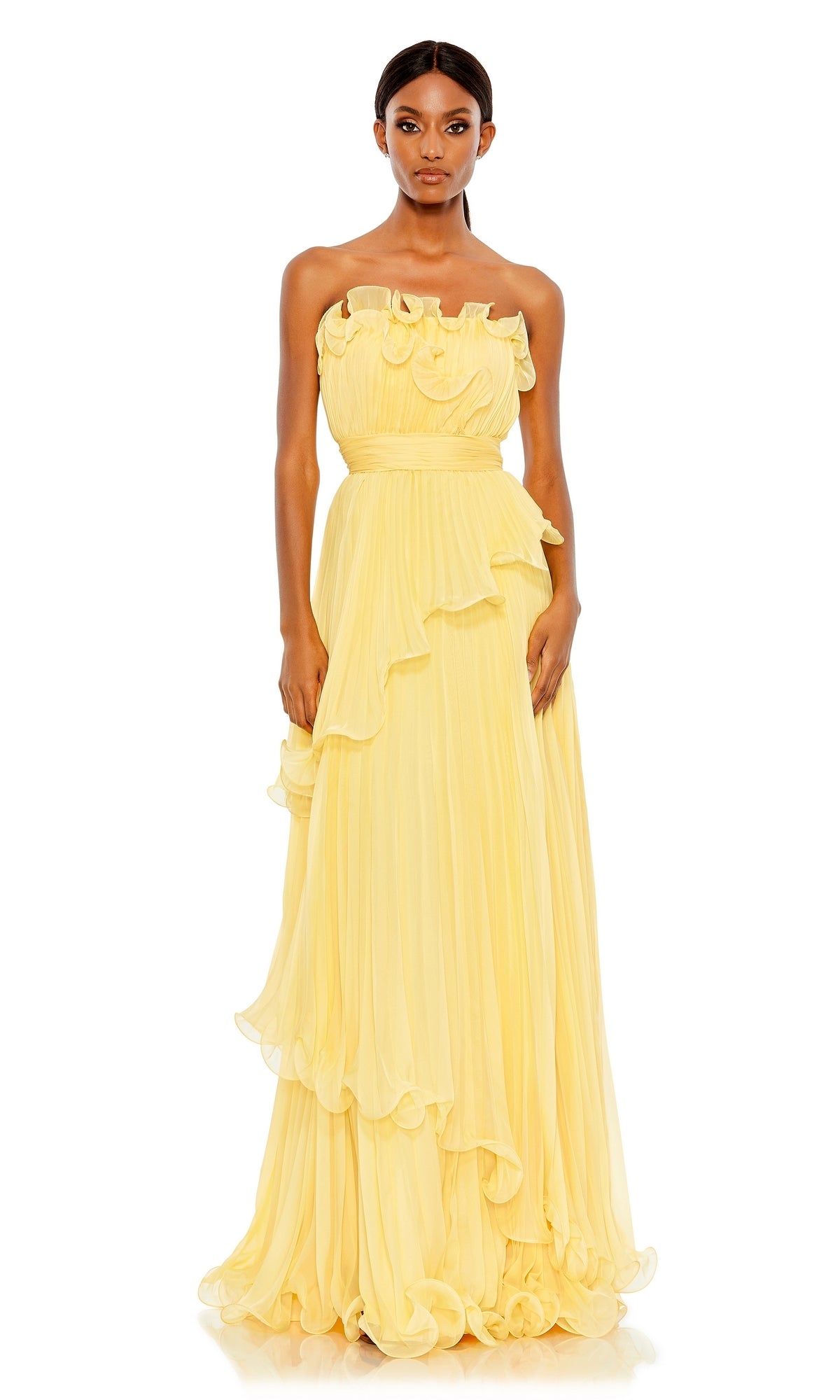 A woman stands facing forward against a white background, wearing the Long Formal Dress 49537 by Mac Duggal—a strapless, empire waist gown with a floor-length pale yellow ruffled skirt.