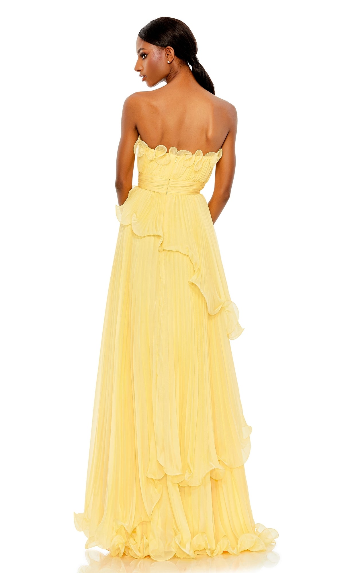 A woman faces away, wearing Mac Duggal’s Long Formal Dress 49537: a yellow strapless gown with an empire waist, ruffled accents, and a pleated floor-length skirt.