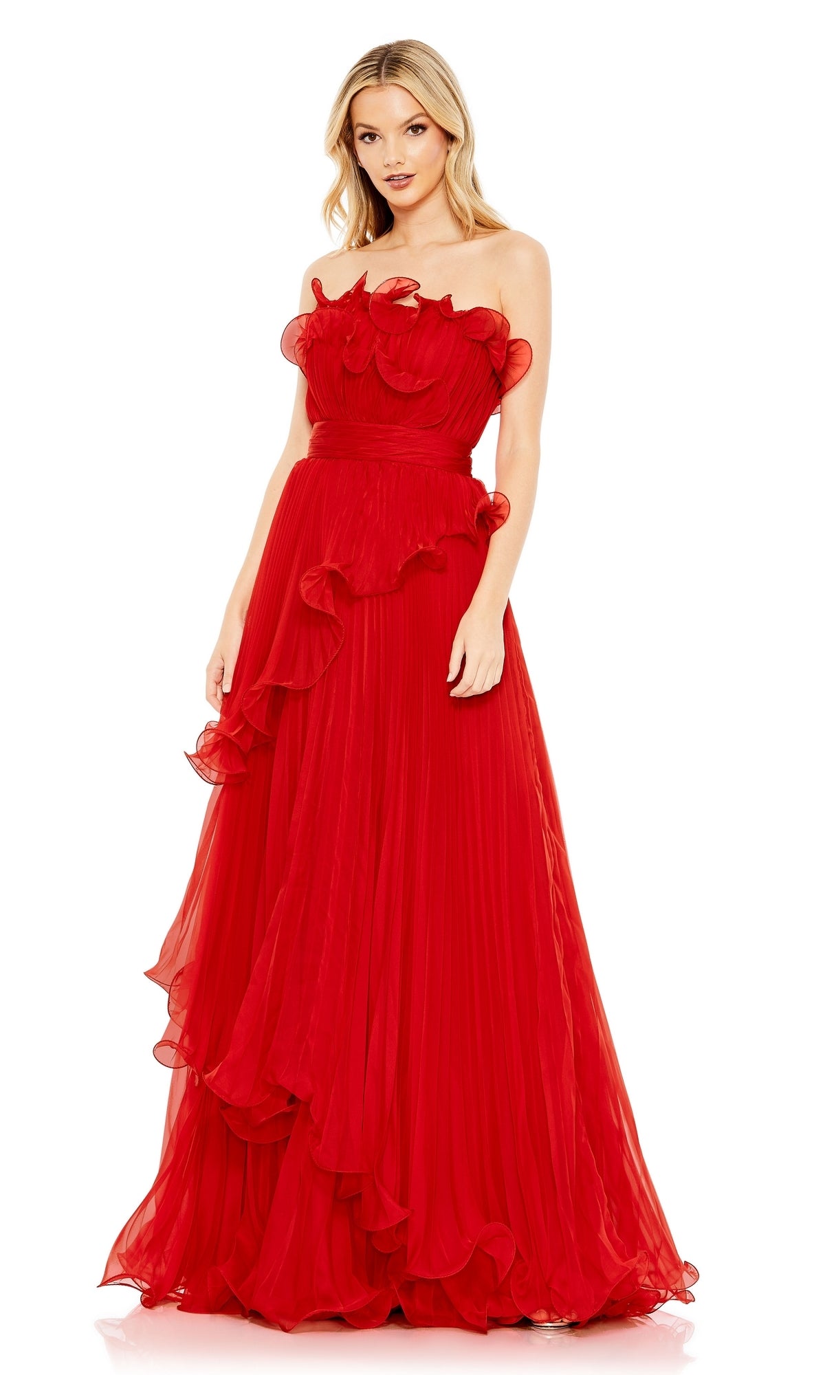 A woman wears the Long Formal Dress 49537 by Mac Duggal, a strapless, floor-length red gown featuring ruffled details and a pleated skirt, standing against a white background.