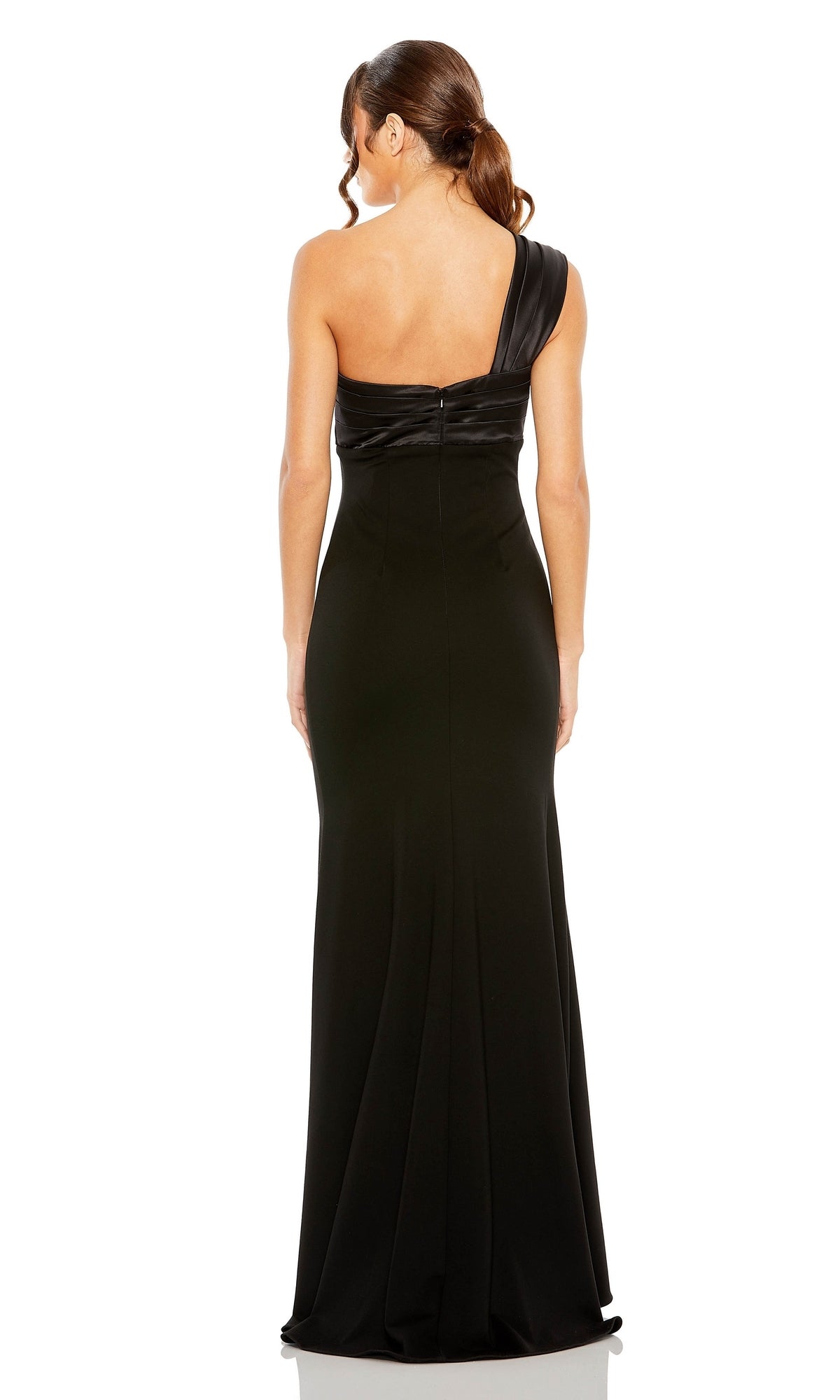 A woman with brown hair in a low ponytail wears the Mac Duggal One-Shoulder Long Bow Prom Dress 49547, standing and facing away from the camera.