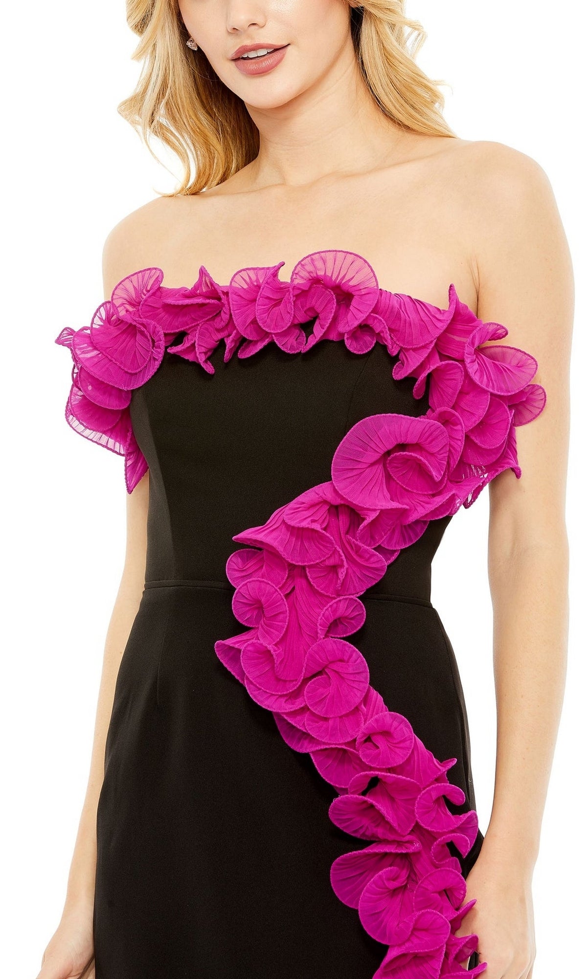 A woman wears the Short Homecoming Dress 49642 by Mac Duggal—a strapless black party dress featuring bright pink ruffled floral accents along the neckline and diagonally across the fitted bodice for a striking look.