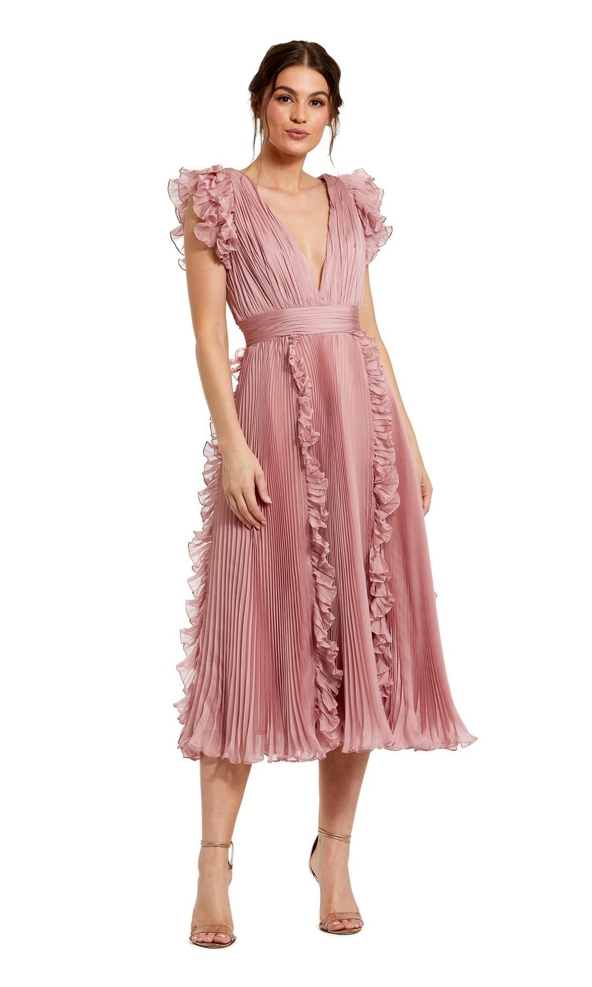 A woman wears the Mac Duggal Short Wedding Guest Dress 49675 in rose pink chiffon, featuring ruffle cap sleeves, a deep V-neckline, pleated skirt, and strappy nude heelsโa chic choice for any party.