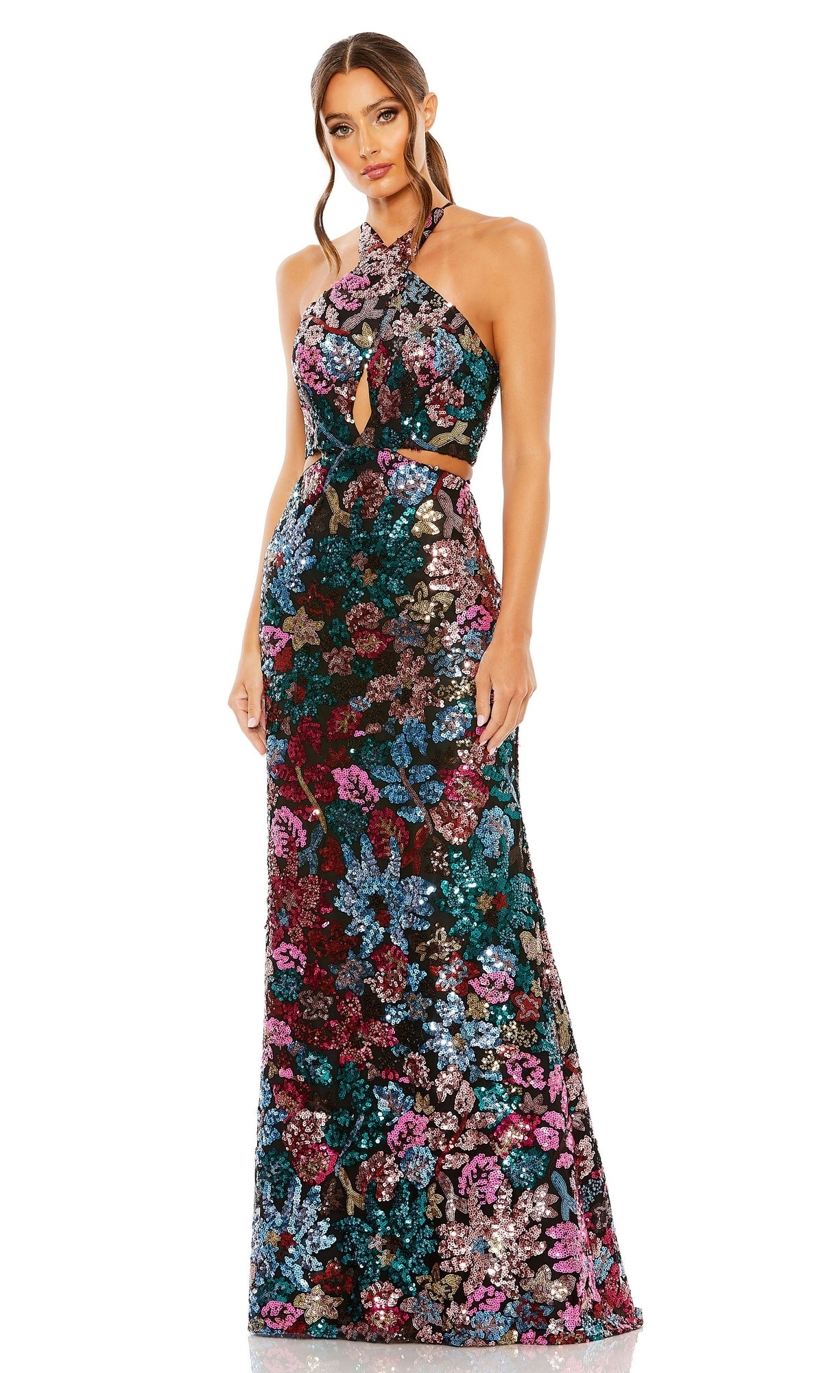 A woman wears the Mac Duggal 49695 Multicolor Sequin Formal Dress, a floor-length, sleeveless halter gown featuring floral sequin patterns and cutout details at the waist and neckline.