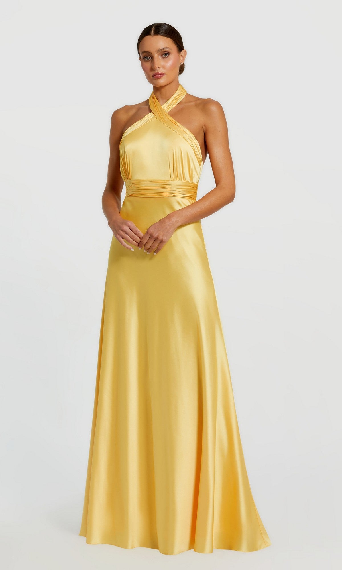 A woman faces forward in a Mac Duggal 49728 long formal dress in lemon, featuring a halter neck and floor-length satin design, set against a plain light background.