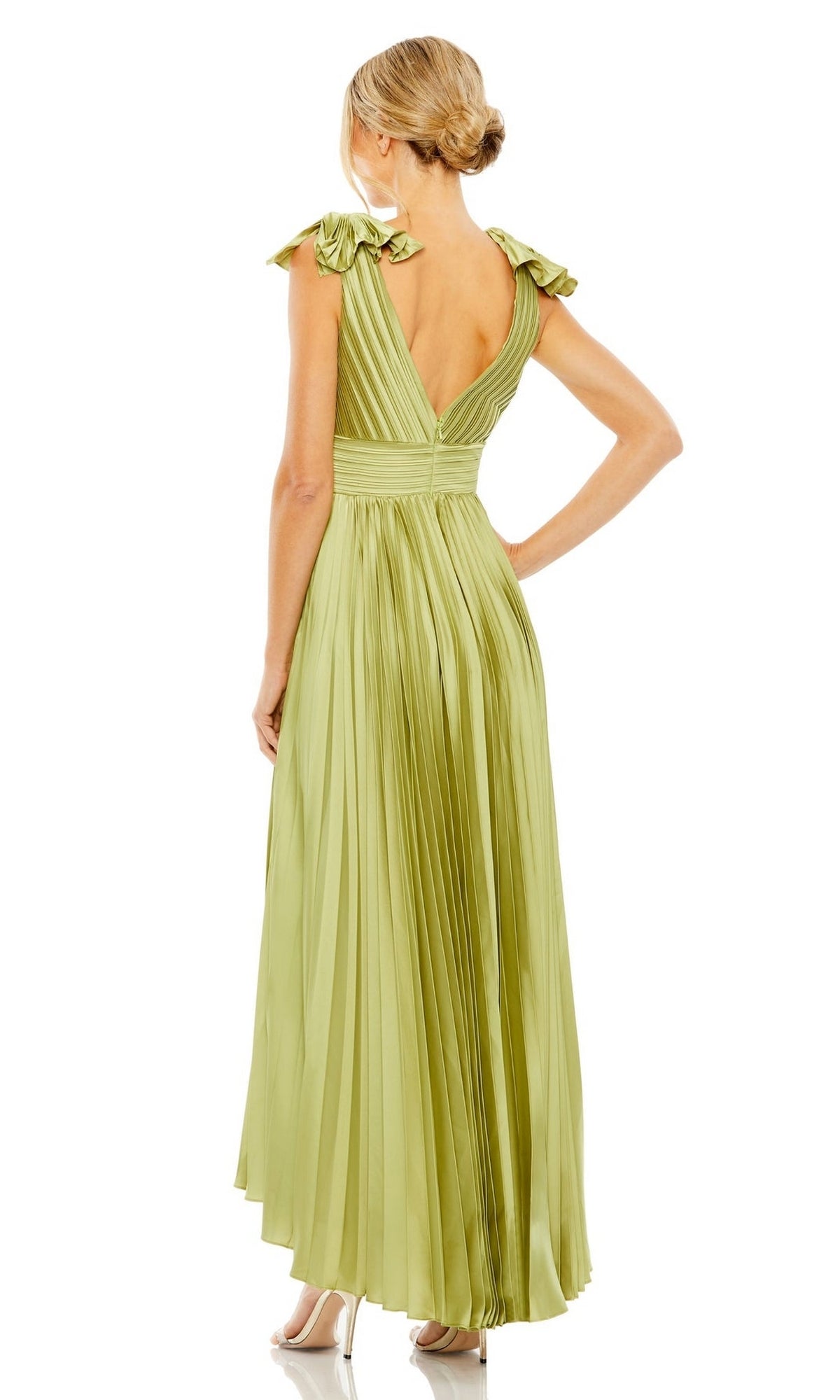 A woman stands facing away, wearing a light green, pleated tea-length Mac Duggal 49734 formal dress with cap sleeves and a deep V-back.