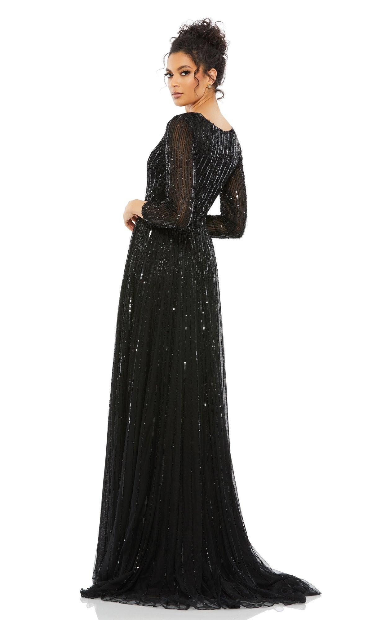 A woman stands facing away, looking over her shoulder, wearing the Long Formal Dress 4977 by Mac Duggal— a long-sleeved, floor-length black formal gown with a v-neckline—against a plain white background.