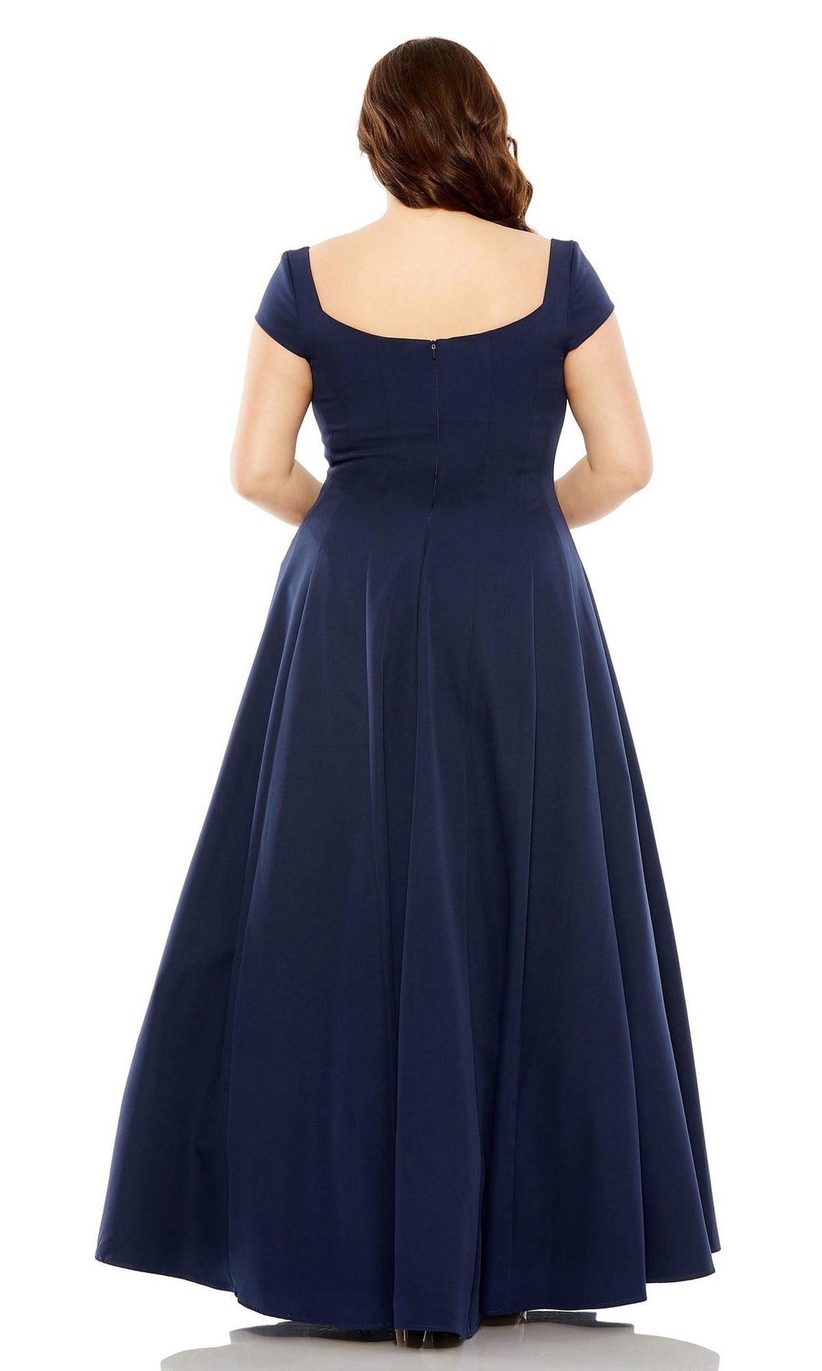 A woman with long brown hair is seen from the back, wearing the Mac Duggal Plus-Size Simple Long Formal Dress 49783W, a floor-length navy blue A-line gown with cap sleeves.