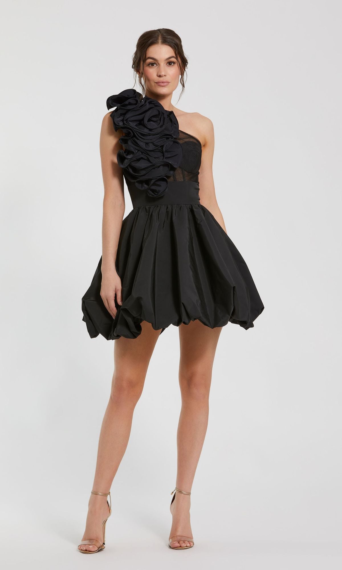 A woman wears the Mac Duggal 49858 Taffeta Short Black Party Dress with ruffle details and metallic heels, standing against a plain white background.