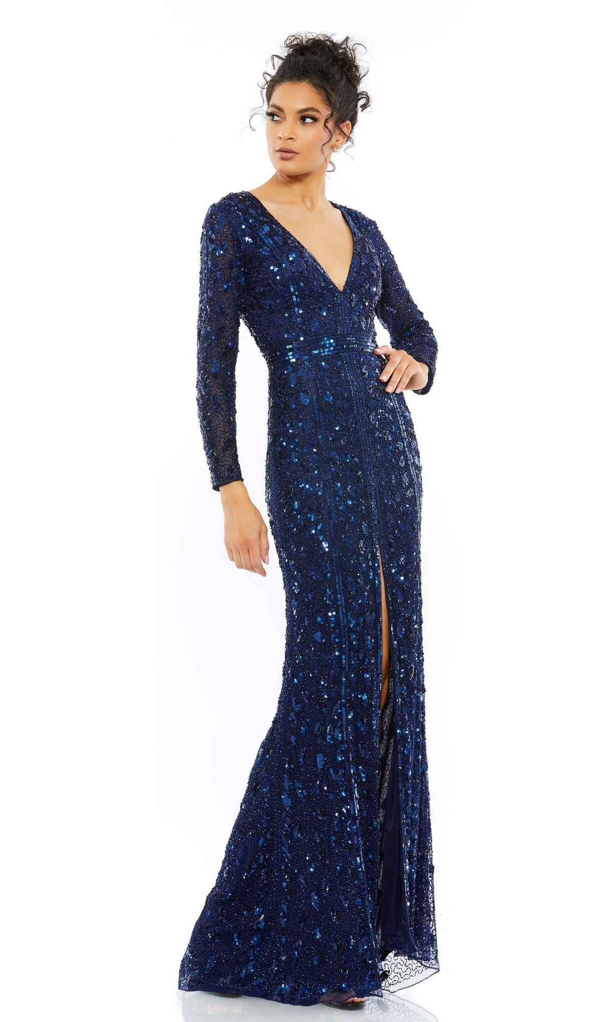 A woman stands against a white background wearing the Long Formal Dress 5002 by Mac Duggal, featuring long sleeves, a deep blue color, beaded details, a V-neckline, and a front slit.