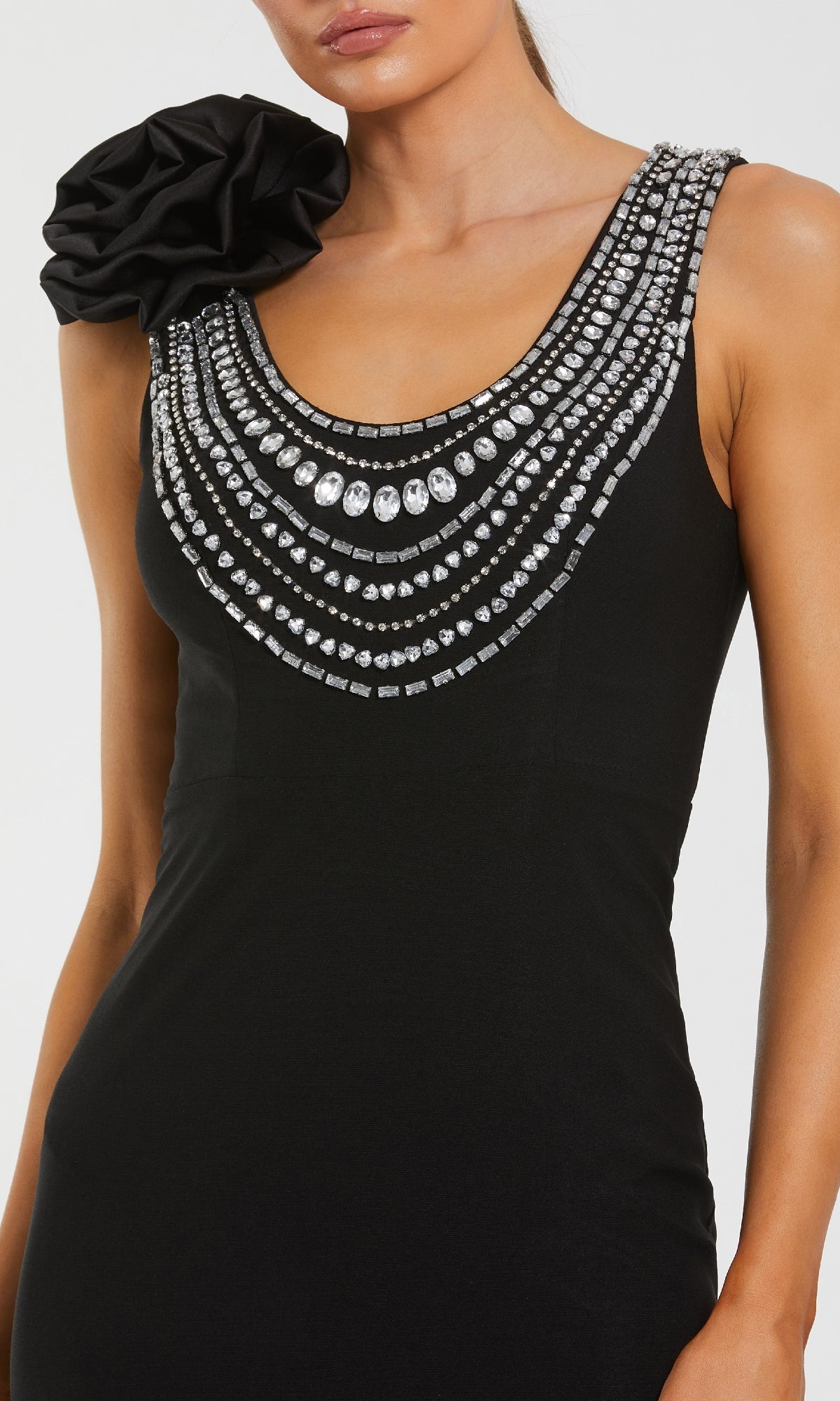 Black dress with intricate silver embellishments on a white background