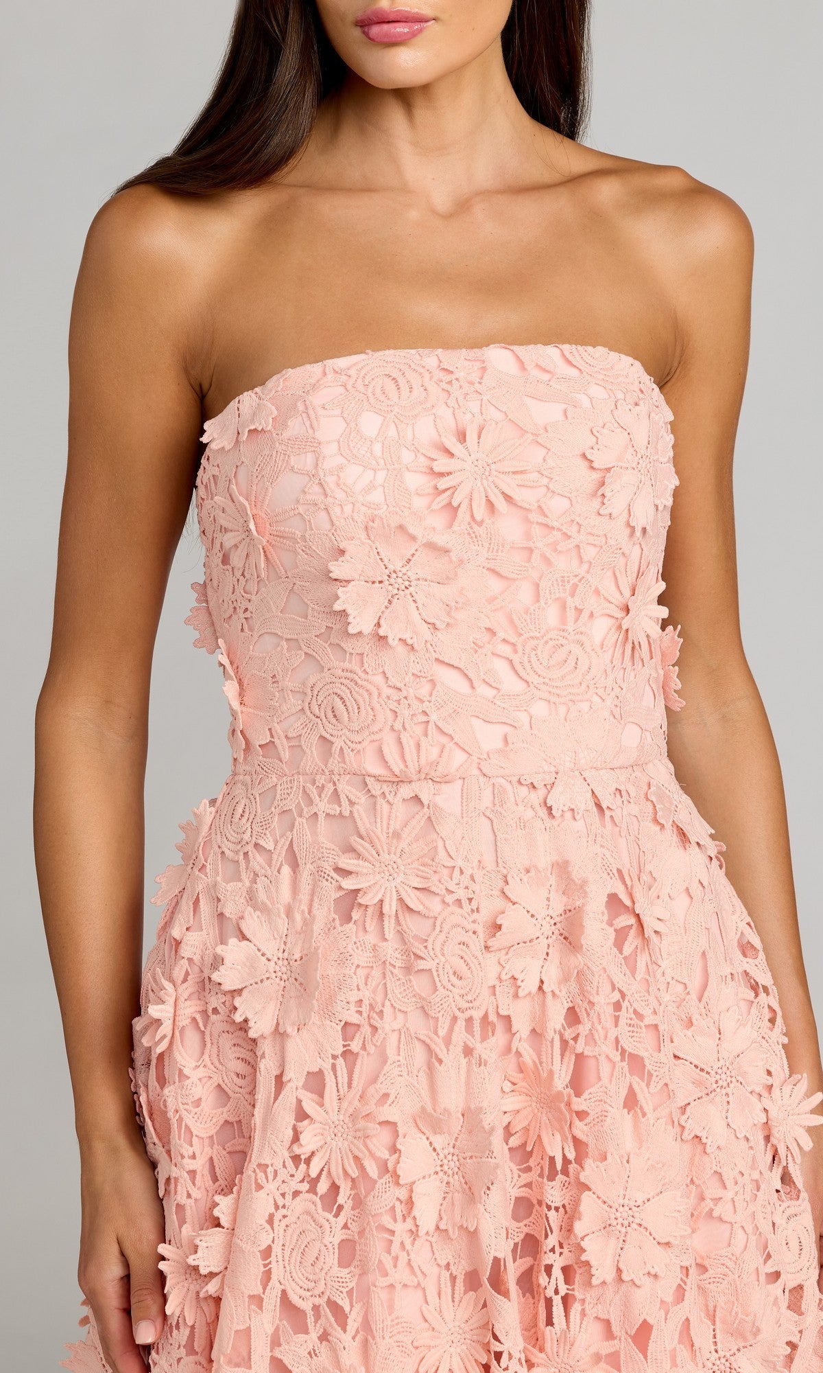 A woman wearing the Mac Duggal 50118 long formal dress, a strapless light pink lace design with elegant floral embroidery, shown from shoulders to mid-thigh.