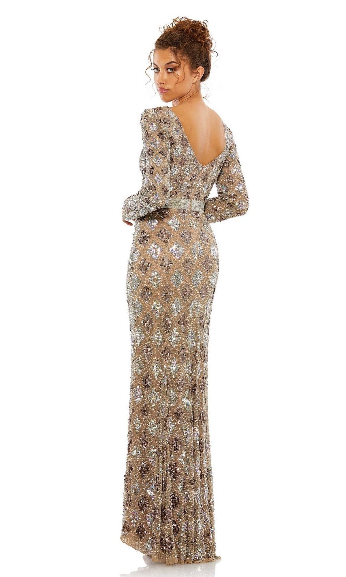 A woman stands against a white background in the Mac Duggal 5021 Long Sleeve Beaded Formal Dress—a floor-length, silver sequin gown with a low back—an elegant mother of the bride choice.