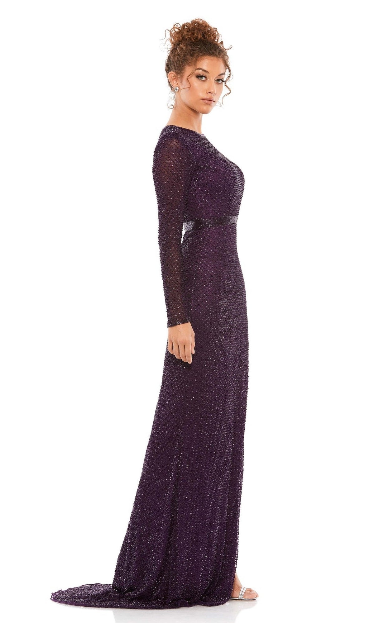 A woman in profile models the Long Formal Dress 5056 by Mac Duggal—a floor-length, dark purple gown with long sleeves, subtle shimmer, and a small train—set against a plain white background.