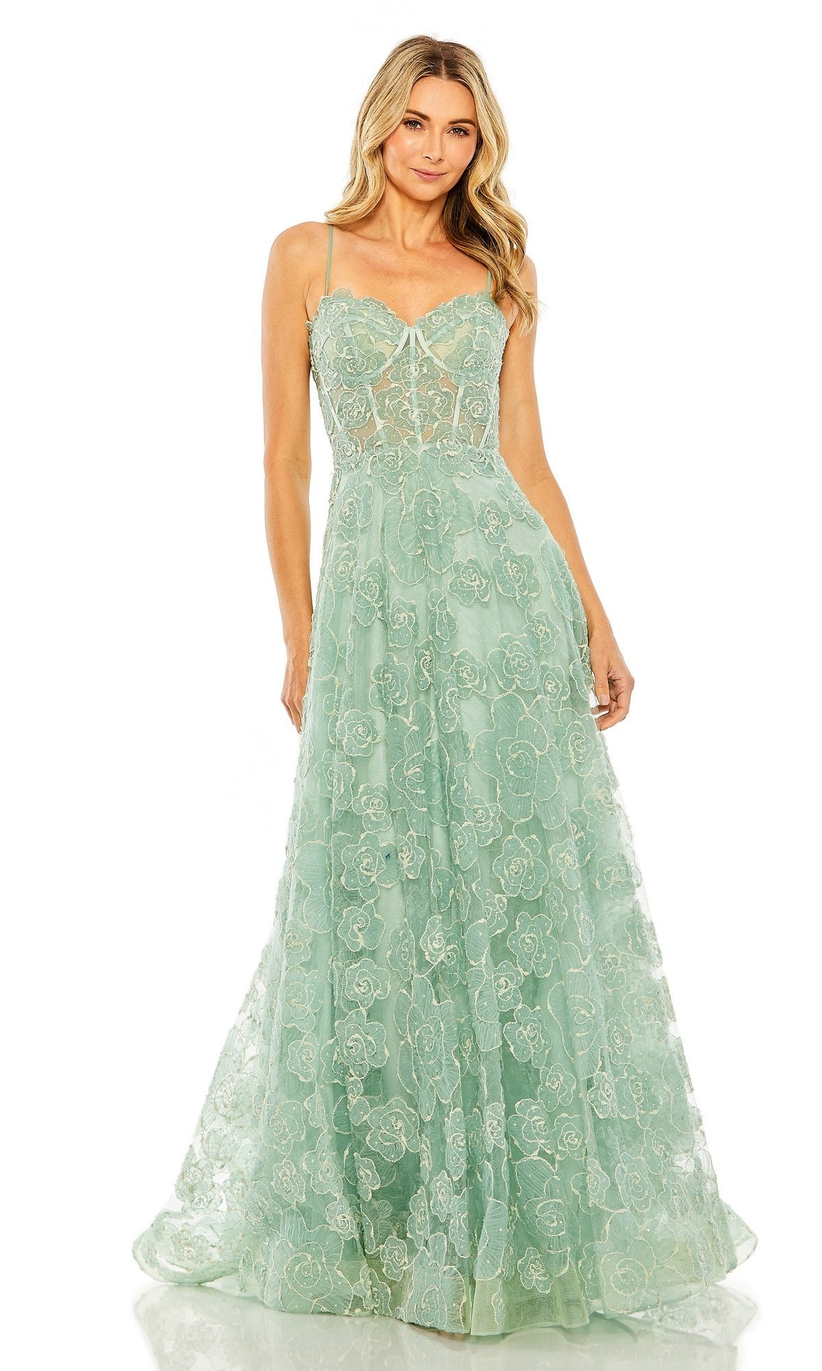 A woman stands facing forward in the Mac Duggal 50735 long formal dress, featuring a mint color, floor-length design, floral embroidery, and thin straps.