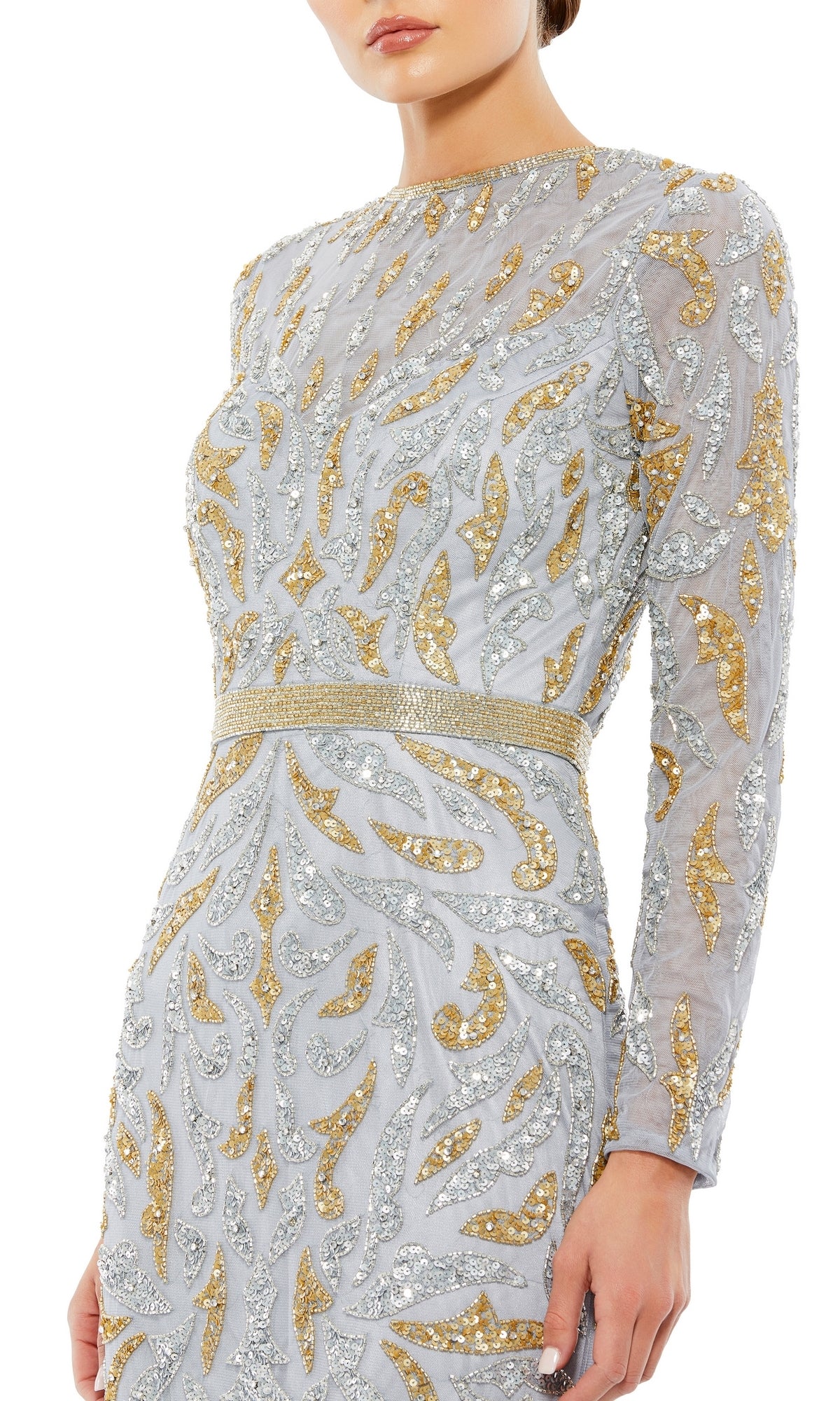 A woman models the Mac Duggal 5124 long sleeve sequin formal dress, featuring silver and gold swirl embellishments. This modest evening gown has fitted long sleeves, with her face partially out of frame.