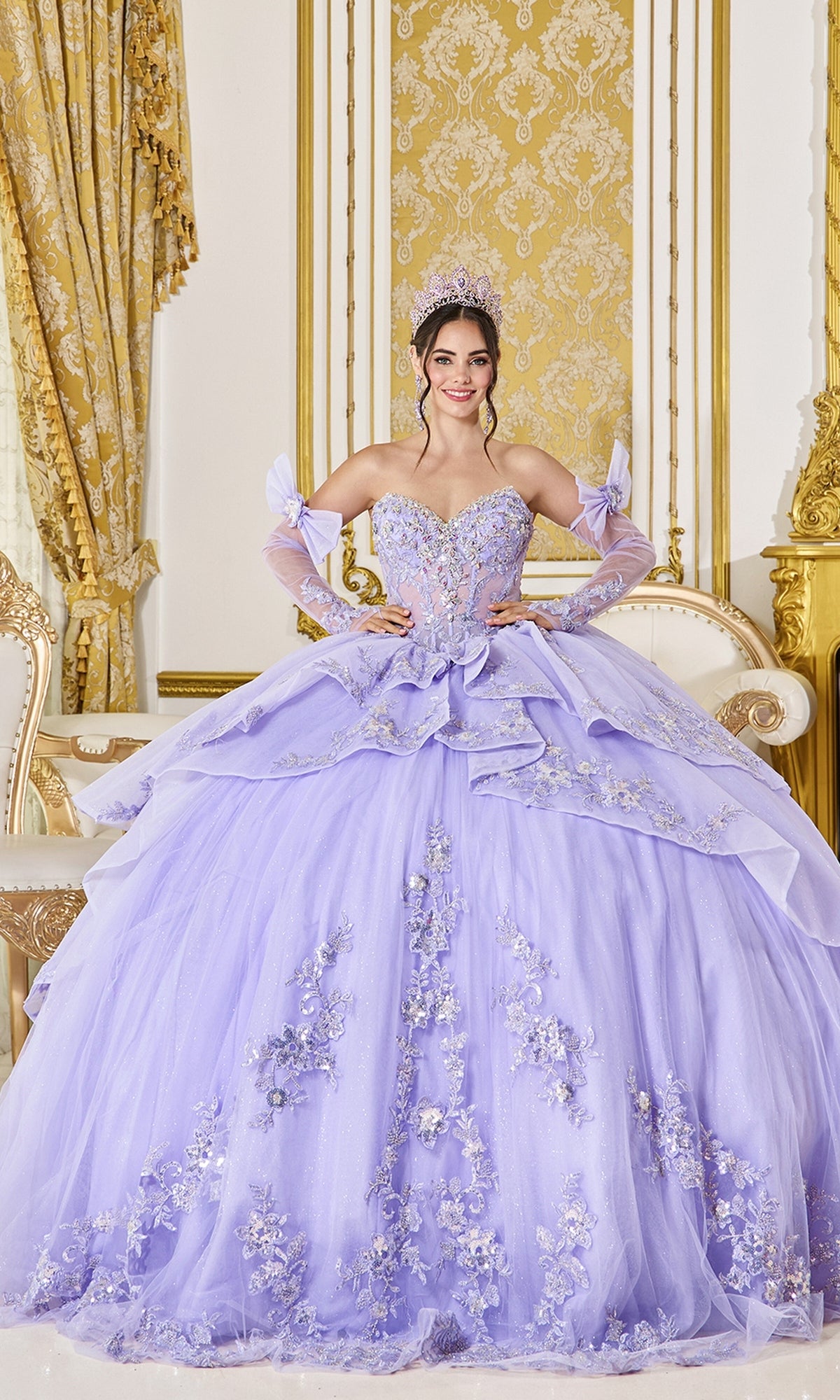 A young woman wears a lilac Quinceanera Dress 5129 By Dancing Queen featuring a beaded corset bodice, floral embroidery, sheer sleeves, and a tiara.