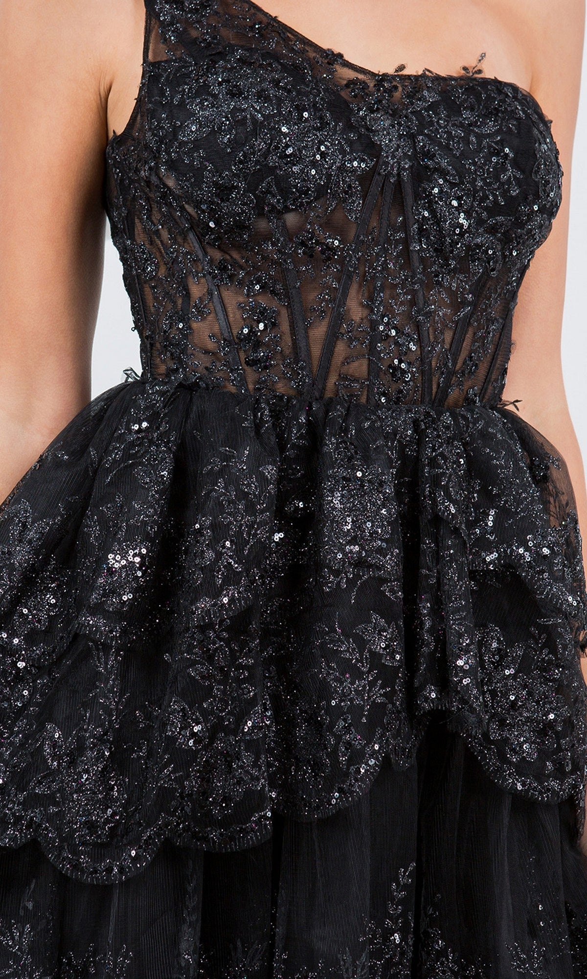 Close-up of the One-Shoulder Short Tiered Homecoming Dress 5132J in black, featuring lace and sequin embellishments, a semi-sheer fabric, and a layered ruffled skirt—an ideal sequin party dress for any semi-formal occasion.