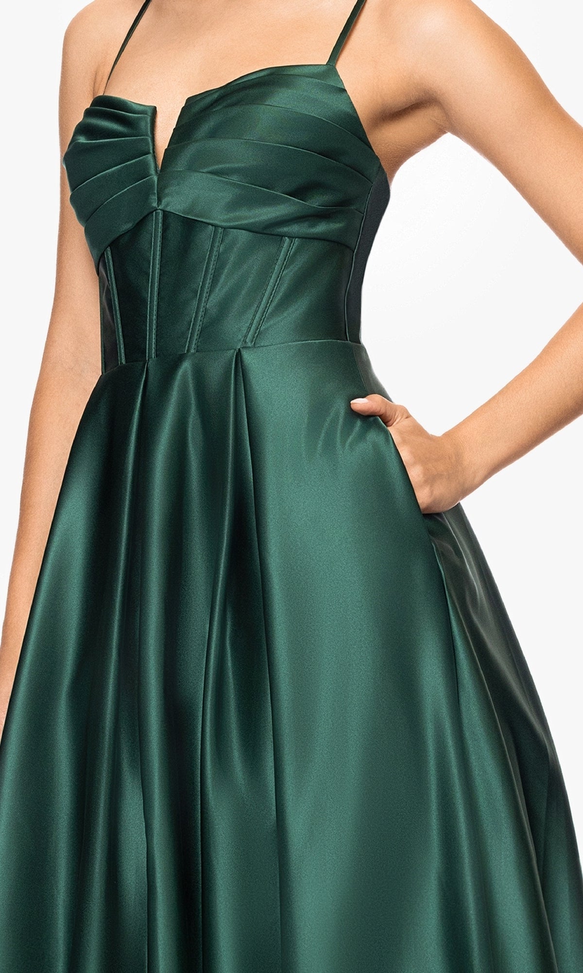 A woman models the Blondie Nites 5207BN long prom dress—an elegant a-line satin gown with a fitted corset bodice, thin straps, pleated skirt, and handy pockets. A stunning evening look under $200.