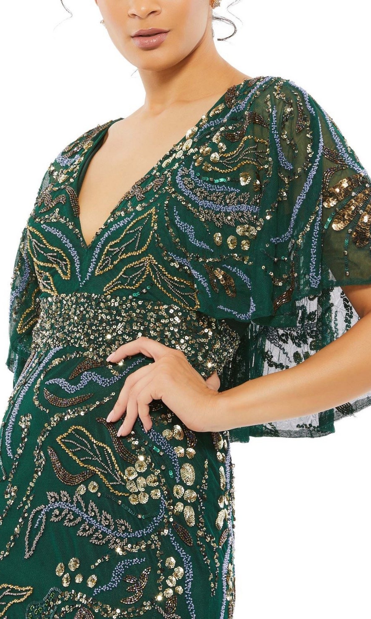 A person wearing the Long Formal Dress 5239 by Mac Duggal—an emerald green gown with gold and blue sequin embroidery, deep V-neckline, and short flutter sleeves.