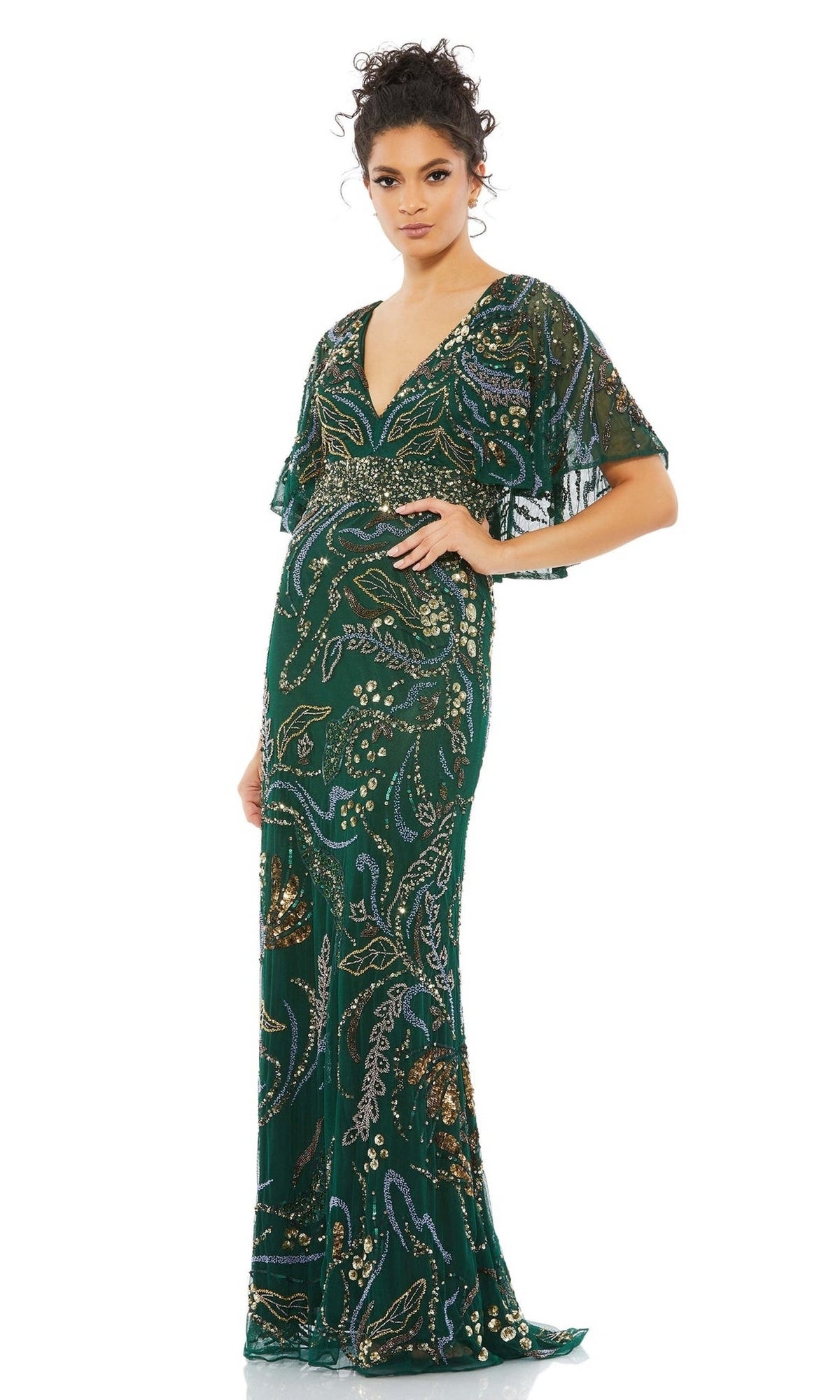 A woman models the Long Formal Dress 5239 by Mac Duggal in emerald green, featuring short flutter sleeves, a deep V-neckline, and intricate beading, standing against a plain white background.