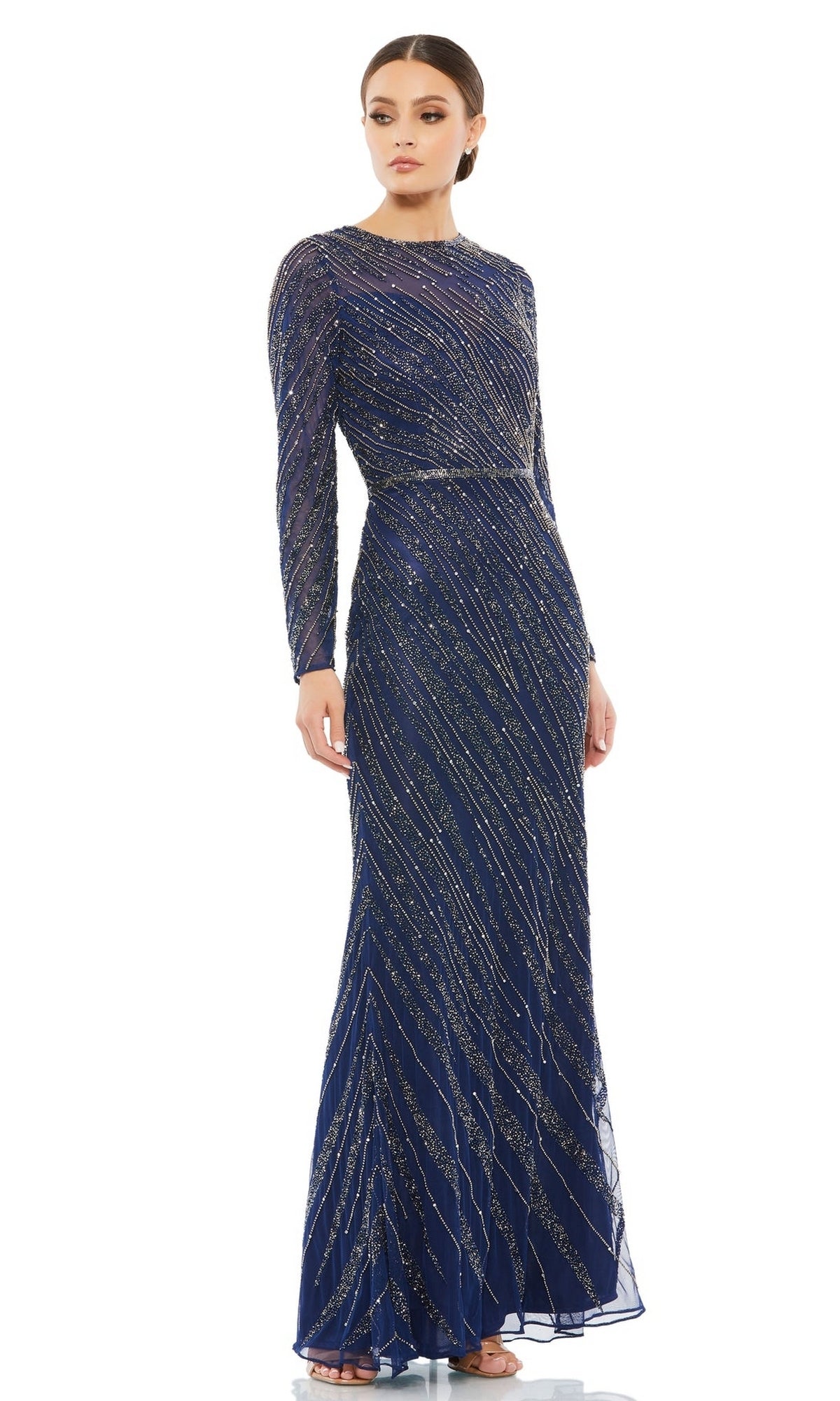 A woman stands against a white background wearing the Mac Duggal 5240 Long Sleeve Sequin Formal Dress, a floor-length gown featuring a high neckline, elegant long sleeves, and shimmering diagonal sequin patterns.
