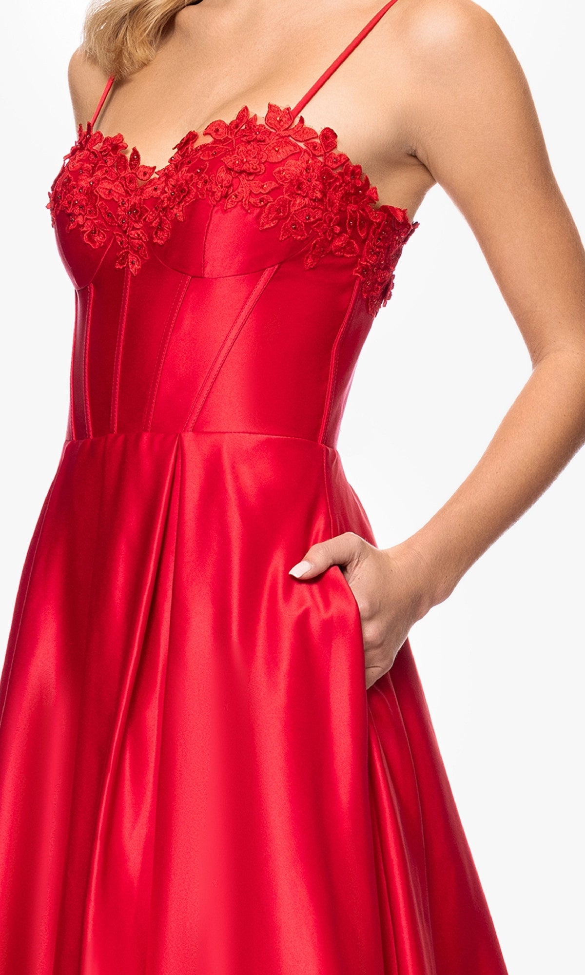 A woman wears the Classic Long Prom Dress: Blondie Nites 5387BN—a fitted, sleeveless red satin gown with embroidered-lace corset bodice, sweetheart neckline, thin straps, and a pocket.