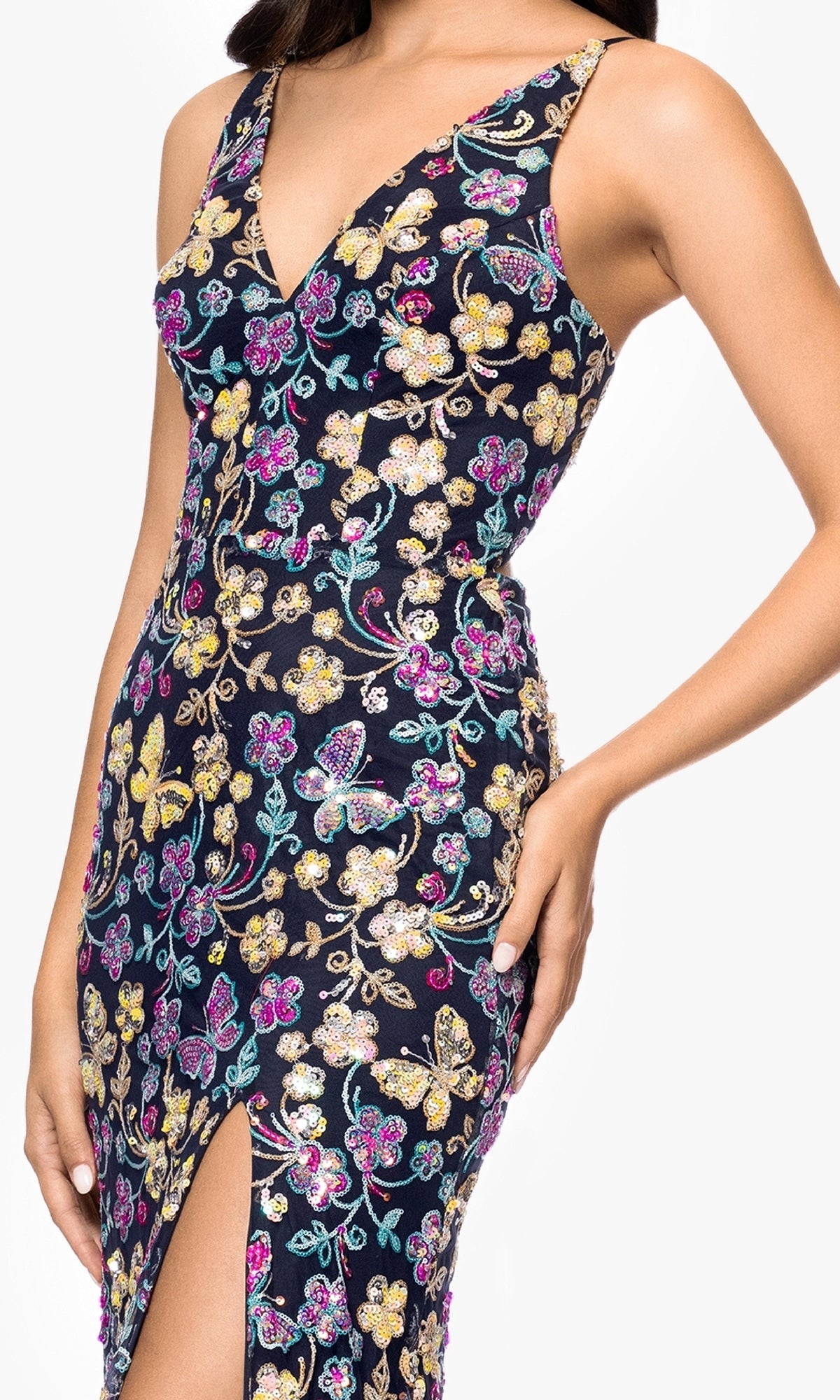 A woman wearing the Sequin Butterfly Prom Gown: Blondie Nites 5402BN—a sleeveless, form-fitting dress with a deep V-neck, sequin butterfly embroidery, and a thigh-high slit.