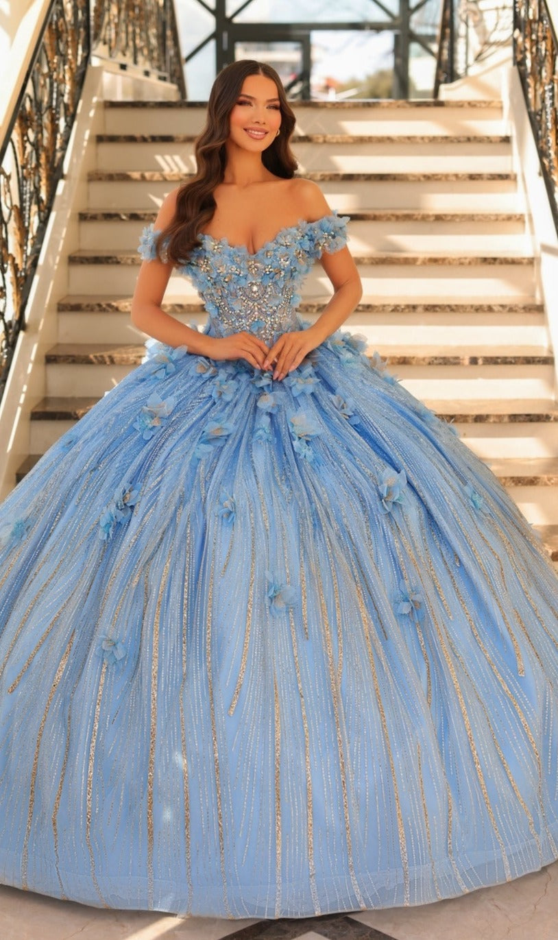 A woman stands on stairs wearing the Quinceanera Dress 54226 by Amarra, an off-the-shoulder light blue ball gown with delicate floral appliqué and shimmering silver accents.