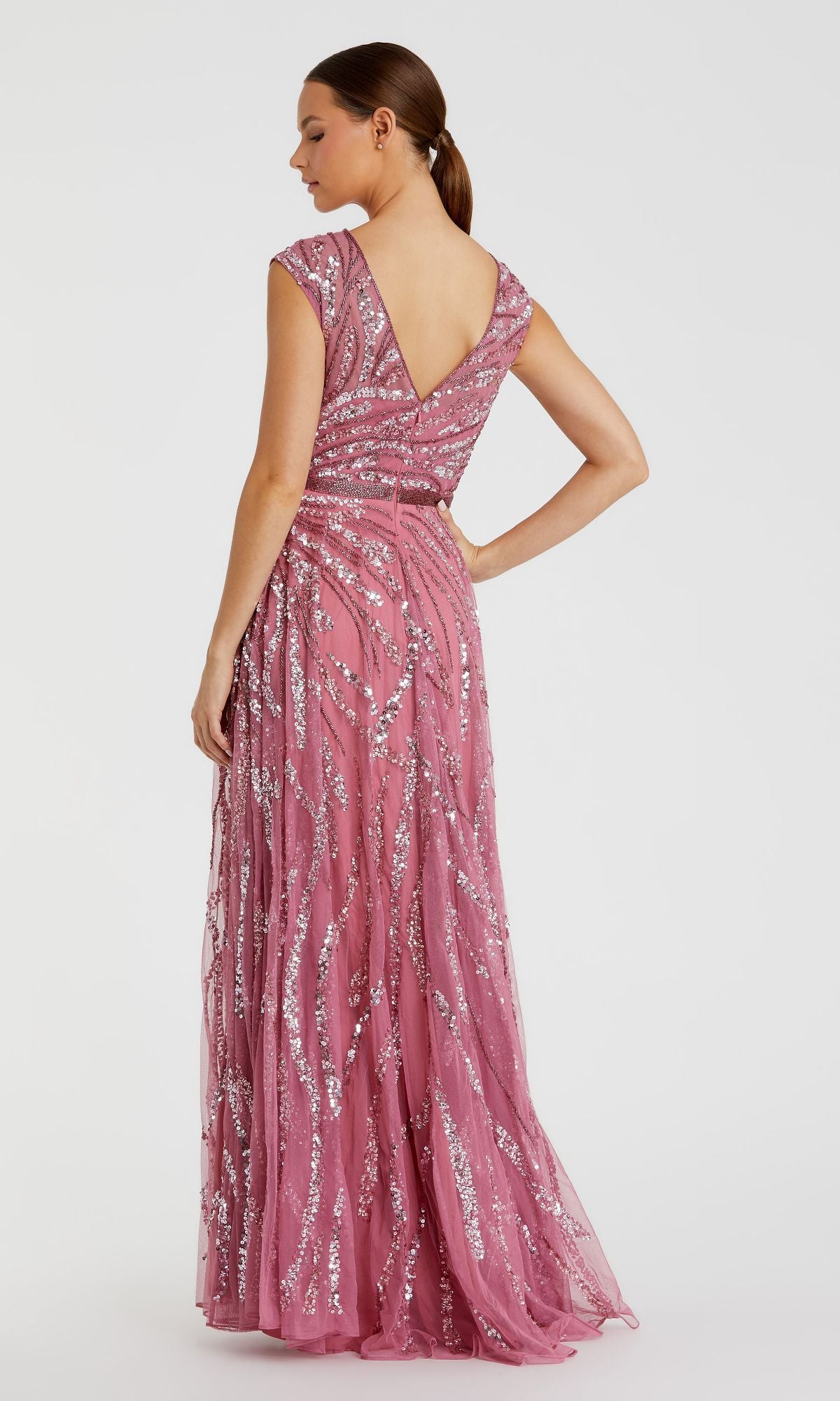 Woman in a floor-length, high-neck beaded Mac Duggal 5445 formal gown stands with one hand on her hip against a plain background.