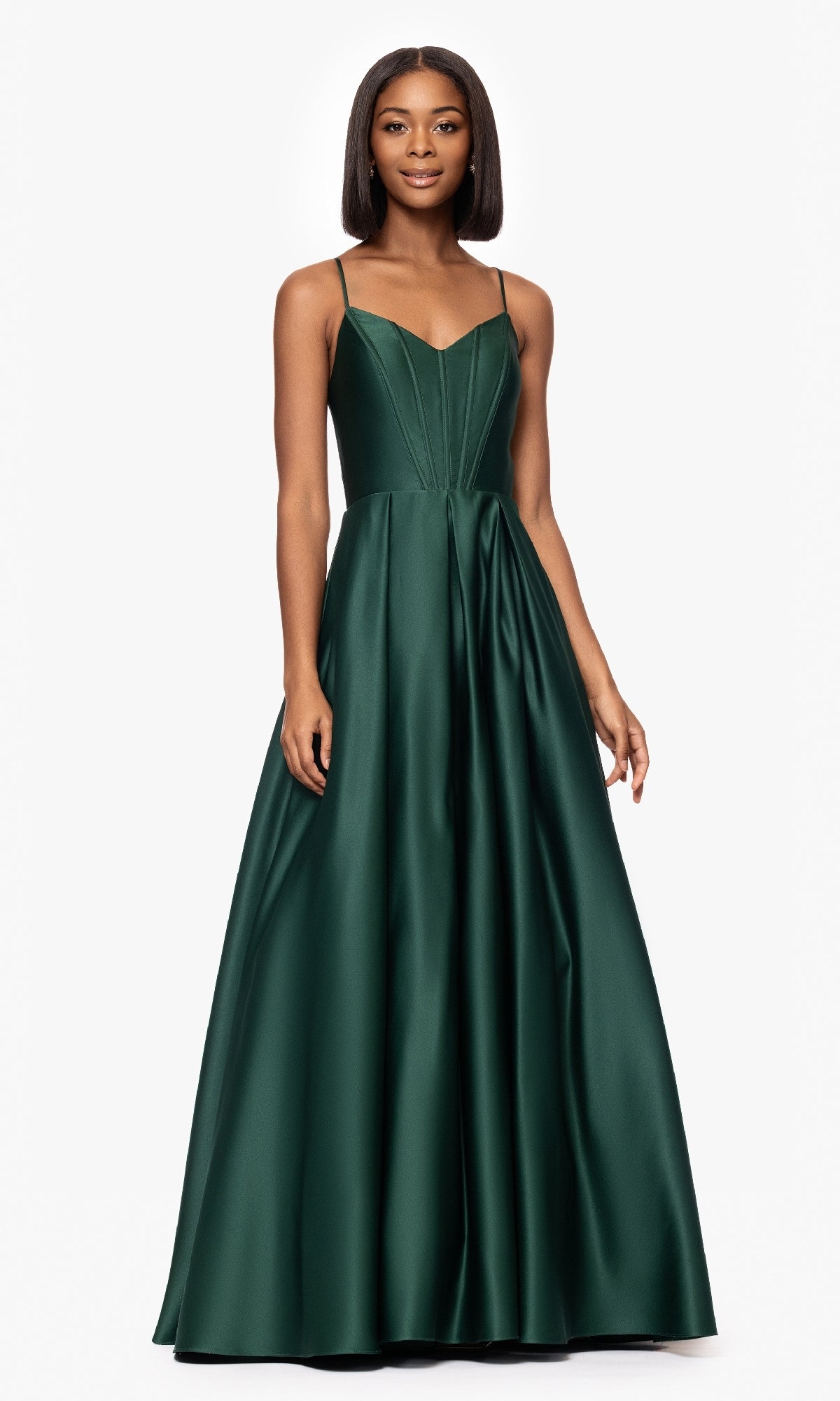 A woman models the Blondie Nites 5446BN Classic Long Prom Dress, featuring a sleeveless, floor-length dark green satin gown with a v-neck corset bodice and thin straps, against a plain white background.