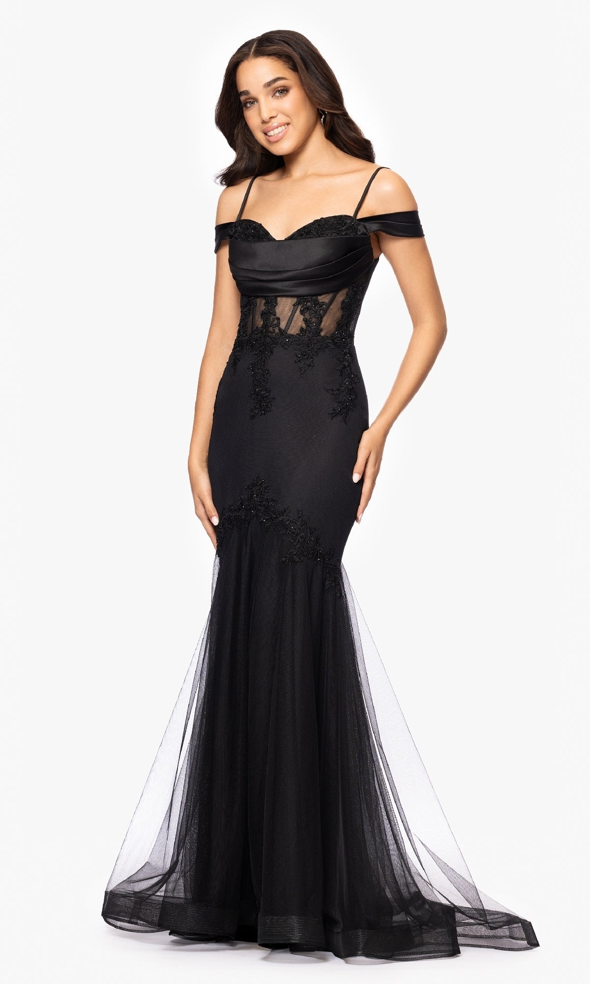 A woman poses against a white background wearing the Black Long Prom Dress: Blondie Nites 5464BN, featuring lace appliques, an off-shoulder neckline, and a sheer tulle mermaid skirt.