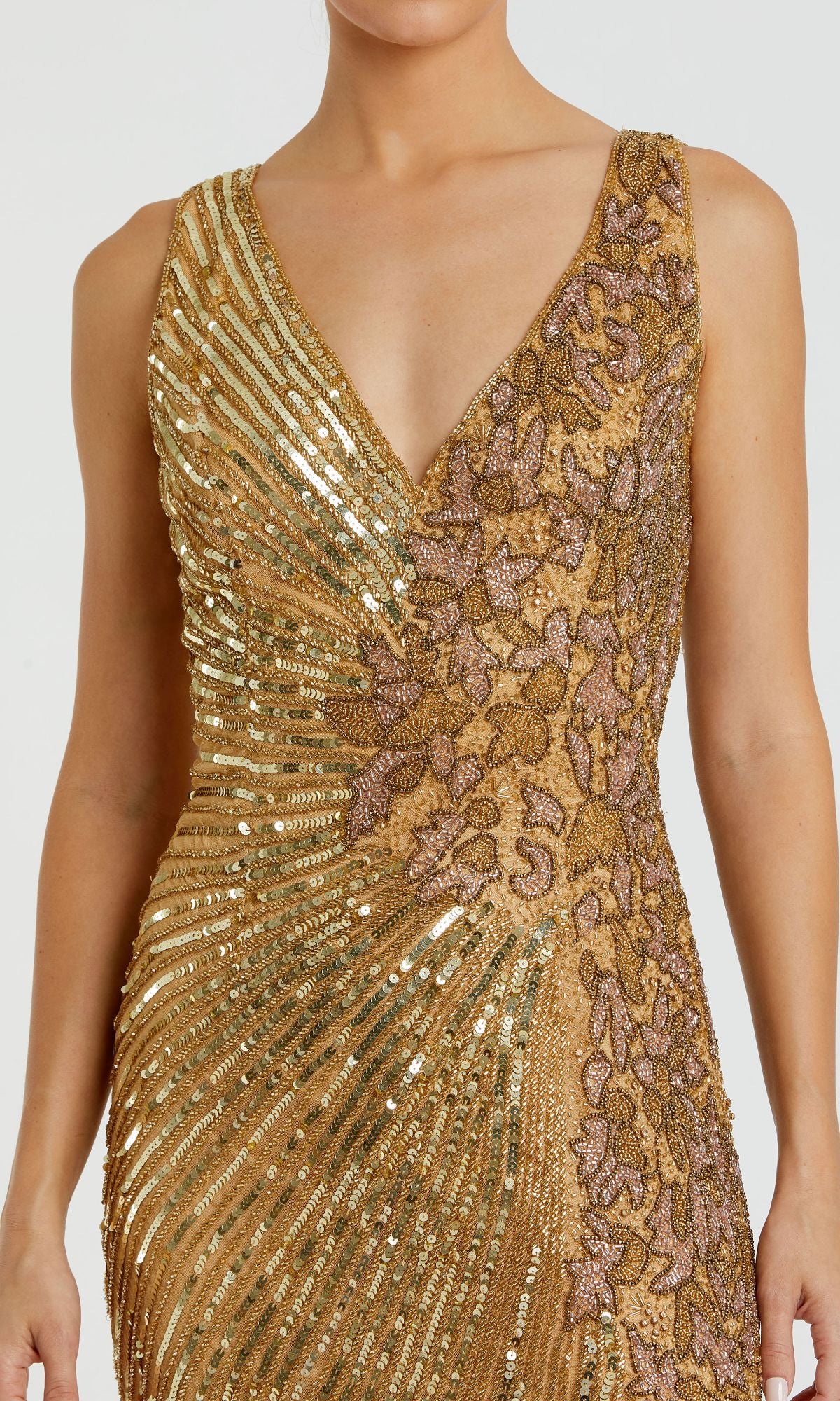 A woman wears the Mac Duggal 5473 Sleeveless Beaded Formal Dress featuring gold sequins, floral embroidery, and a deep V neckline.