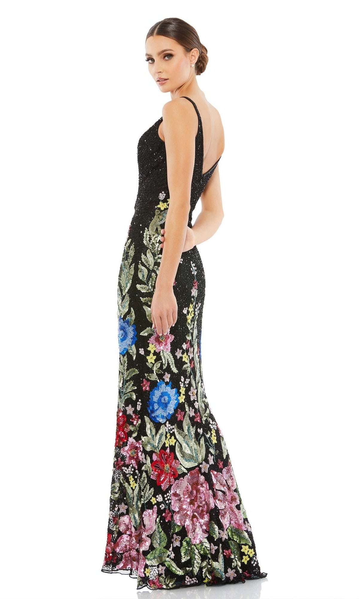 Woman wearing the Mac Duggal 5475 Long Beaded Floral Formal Dress, a sleeveless, floor-length gown with colorful beaded embroidery, stands and looks over her shoulder.
