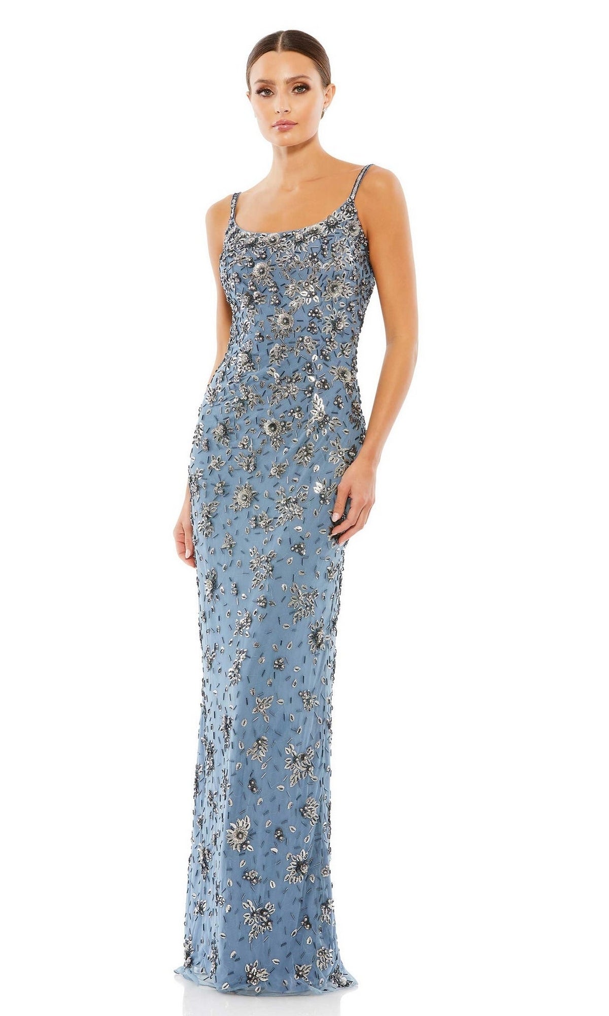 A woman poses in the Mac Duggal 5477 Floral-Beaded Long Formal Dress, a fitted evening gown with silver floral beading and thin straps, set against a plain white background.