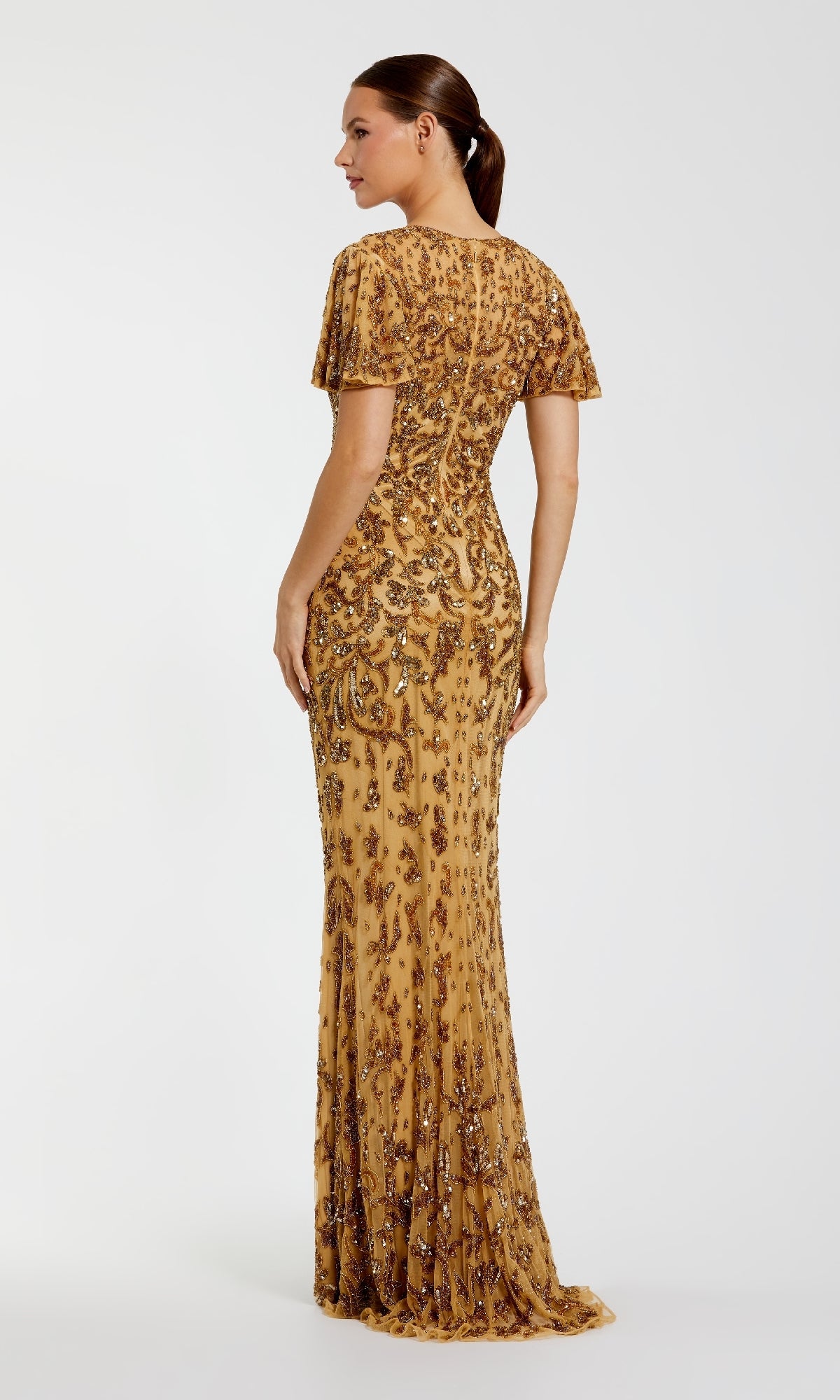 Woman wearing a gold sequin evening gown on a white background