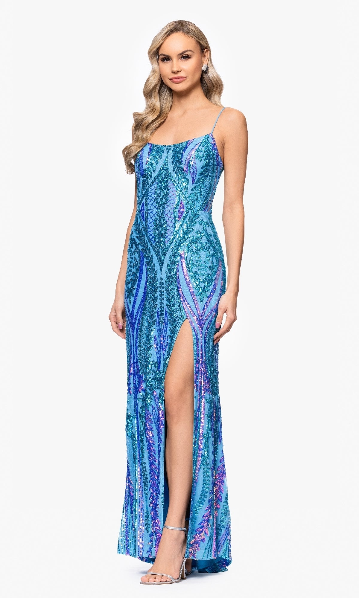 A woman models the Blondie Nites 5493BN long blue sequin prom dress, featuring spaghetti straps and a high leg slit, against a plain white background.
