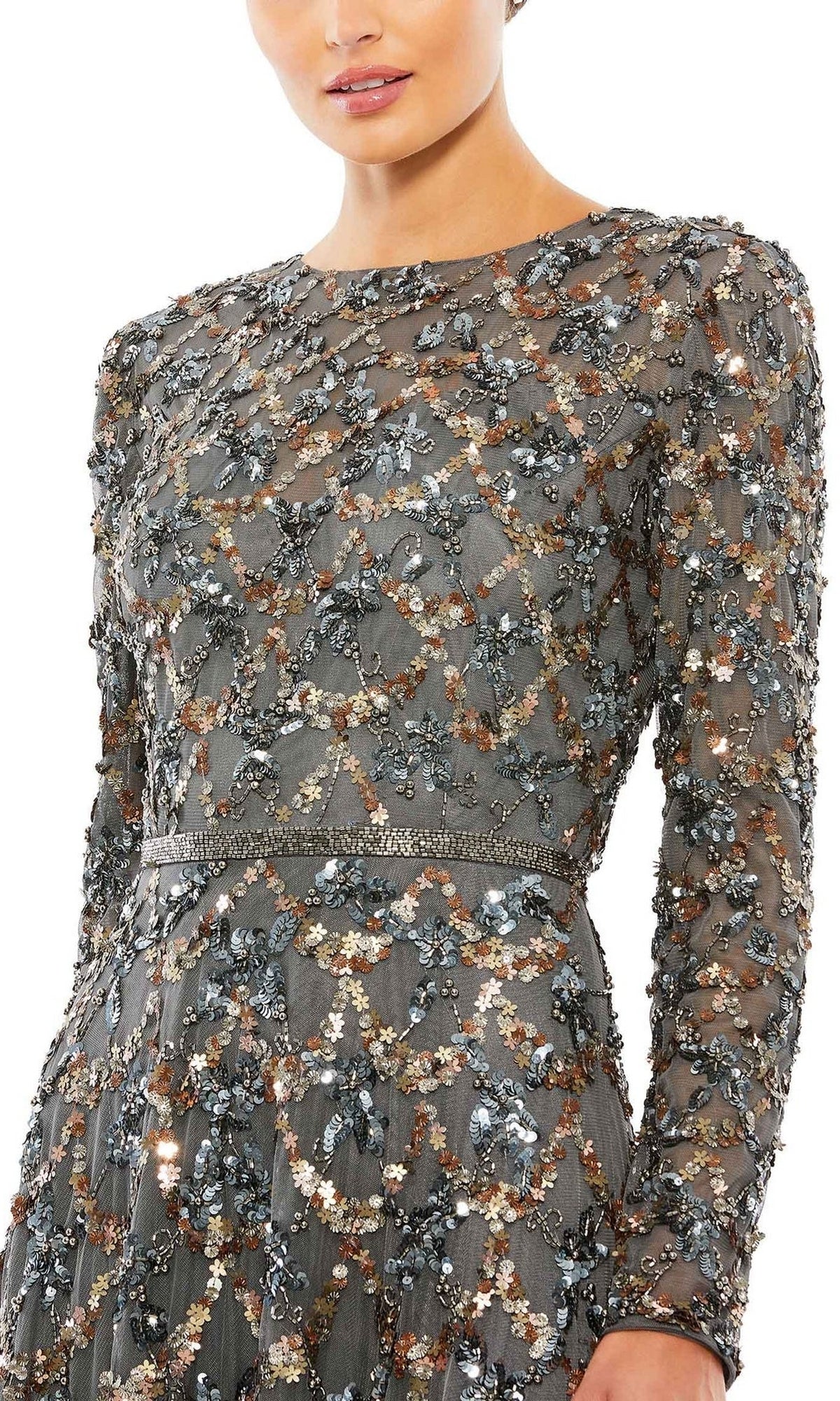 A woman models the Mac Duggal 5496 Long Sleeve Sequin Formal Gown in sheer gray with intricate floral beadwork—an elegant mother of the bride look, shown from shoulders to mid-thigh.