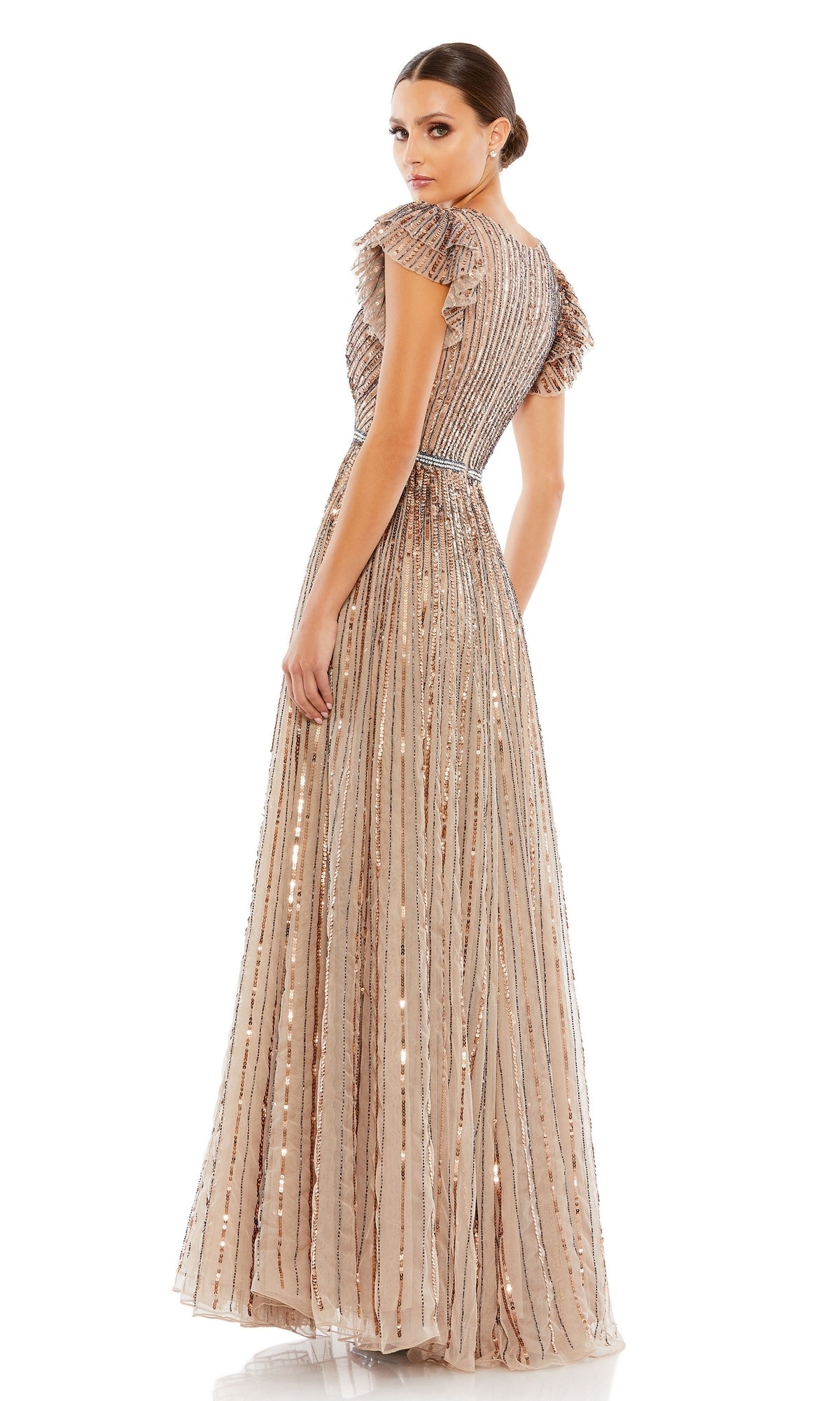 A woman stands against a white background, looking over her shoulder in the Mac Duggal 5502 Sequin-Stripe Long Formal Dress—beige, floor-length, short-sleeved, and adorned with metallic vertical stripes.