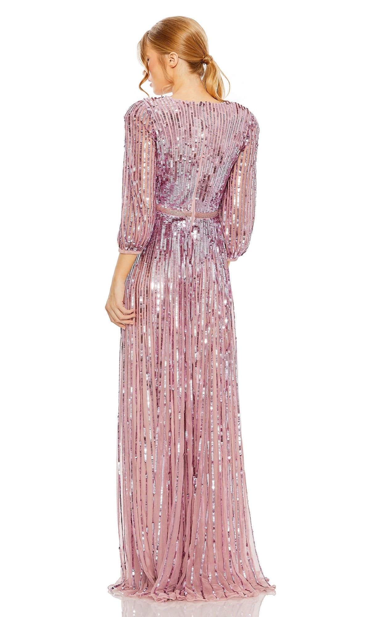 A blonde woman with a ponytail elegantly models the Mac Duggal 5509, a long sleeve, light pink sequin formal dress with sheer sleeves and vertical stripe details, shown from the back.