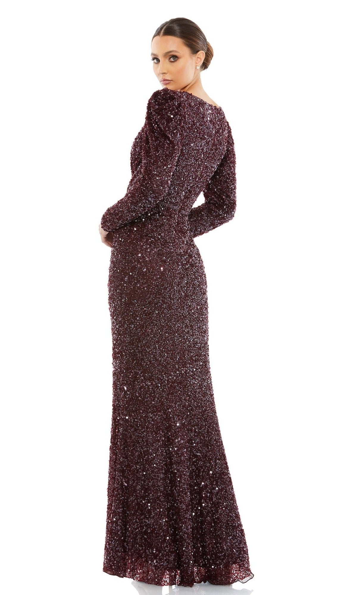 A woman models the Mac Duggal 5510 Long Sleeve Sequin Formal Dress, a floor-length dark maroon gown, posing with her back partially turned and gazing over her shoulder against a white background.