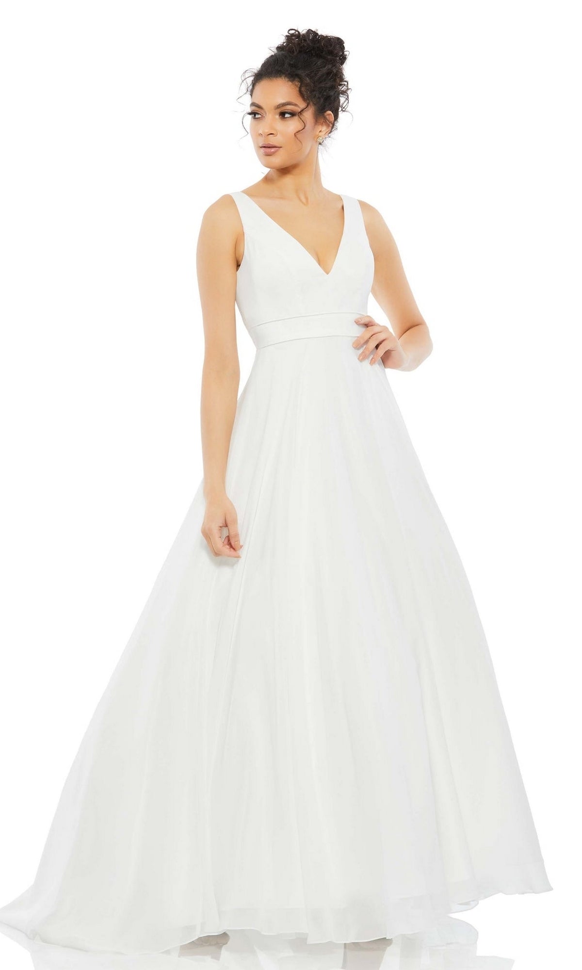 A woman stands against a plain white background wearing the Long Formal Dress 55272 by Mac Duggal, a sleeveless, floor-length white tulle ball gown with a V-neckline.