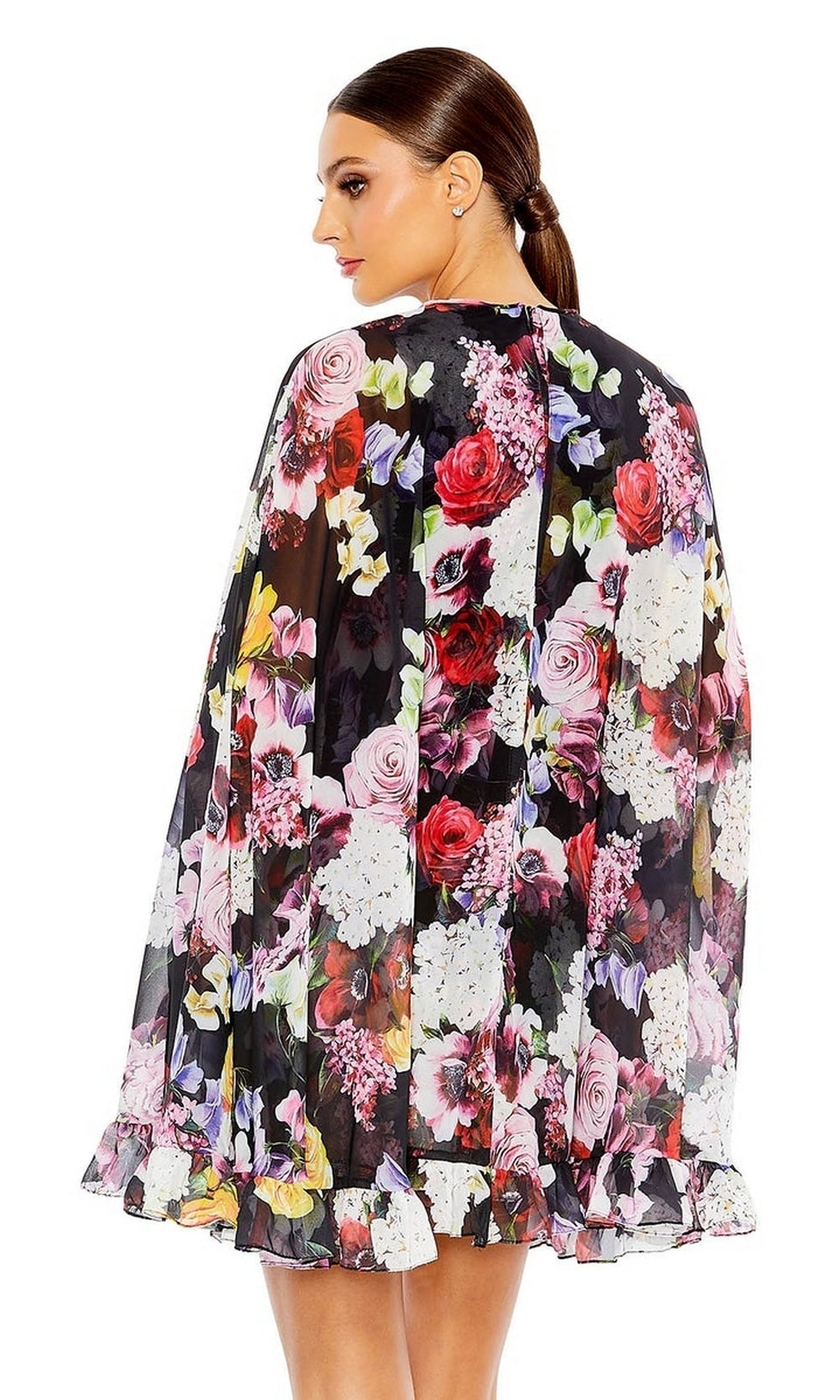 A woman with a sleek ponytail faces away, highlighting the sheer ruffled cape and floral print of the Mac Duggal 55404 Short Print Cape Hoco Dress.