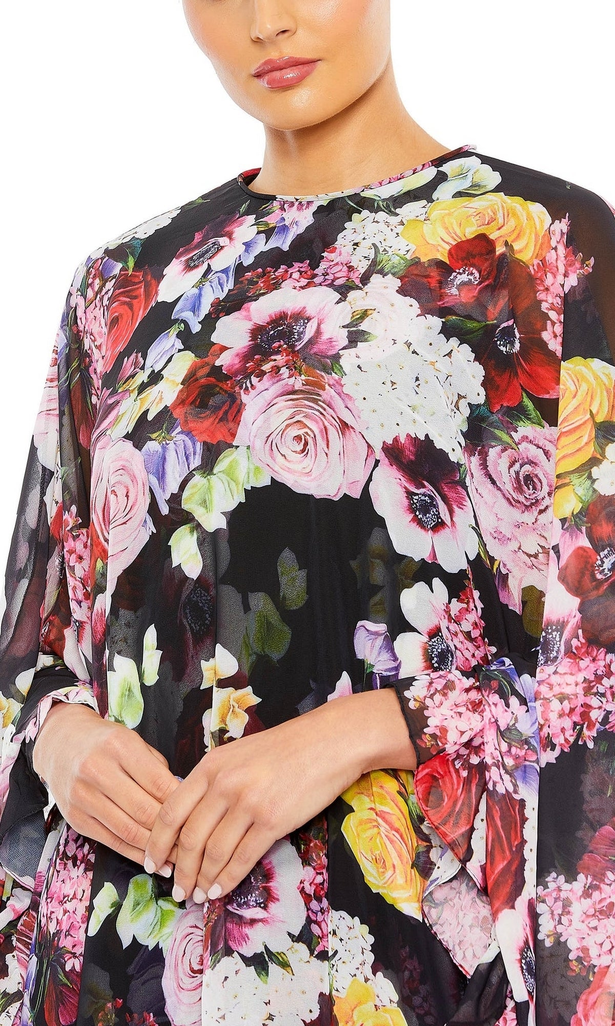 A person wears the Mac Duggal 55404 Short Print Cape Hoco Dress in black mesh with vibrant floral prints—an ideal inspiration for a chic, floral homecoming dress.