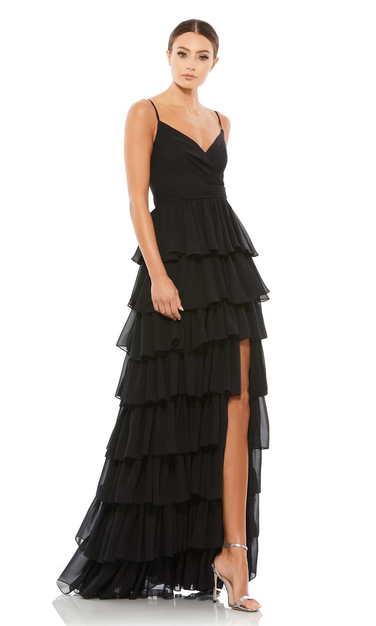 A woman models the Mac Duggal 55416 Ruffled Long A-Line Prom Dress, a sleeveless black evening gown with a high slit, paired with silver heels against a white background.