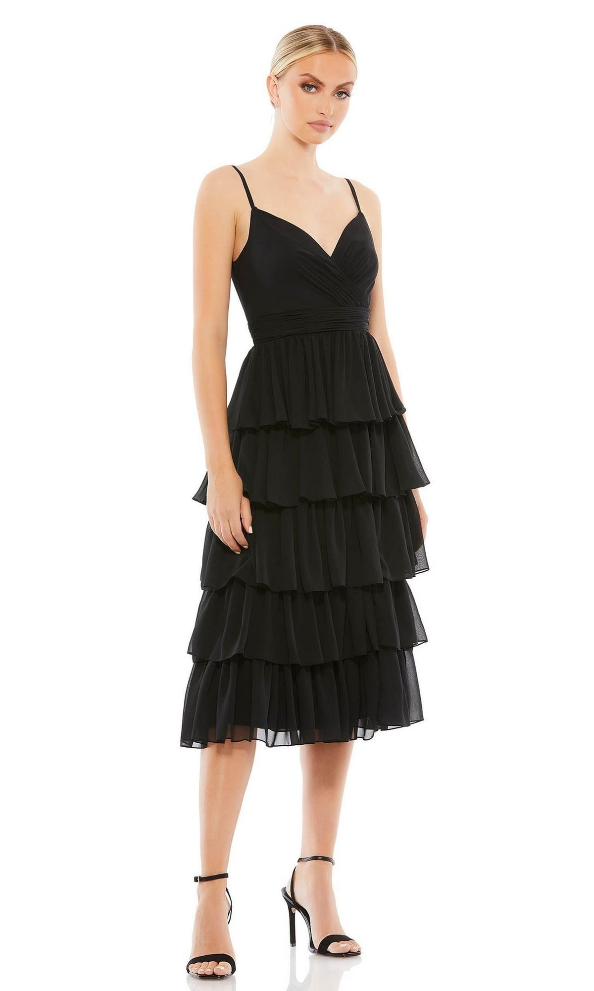 Woman wearing the Mac Duggal 55437 Black Midi Wedding Guest Dress with sleeveless design, tiered ruffle layers, thin straps, and black high-heeled sandals, standing against a plain white background.